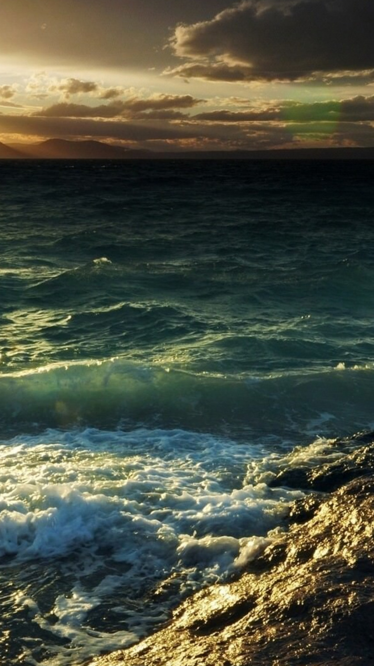 Ocean Waves Crashing on Shore During Sunset. Wallpaper in 750x1334 Resolution
