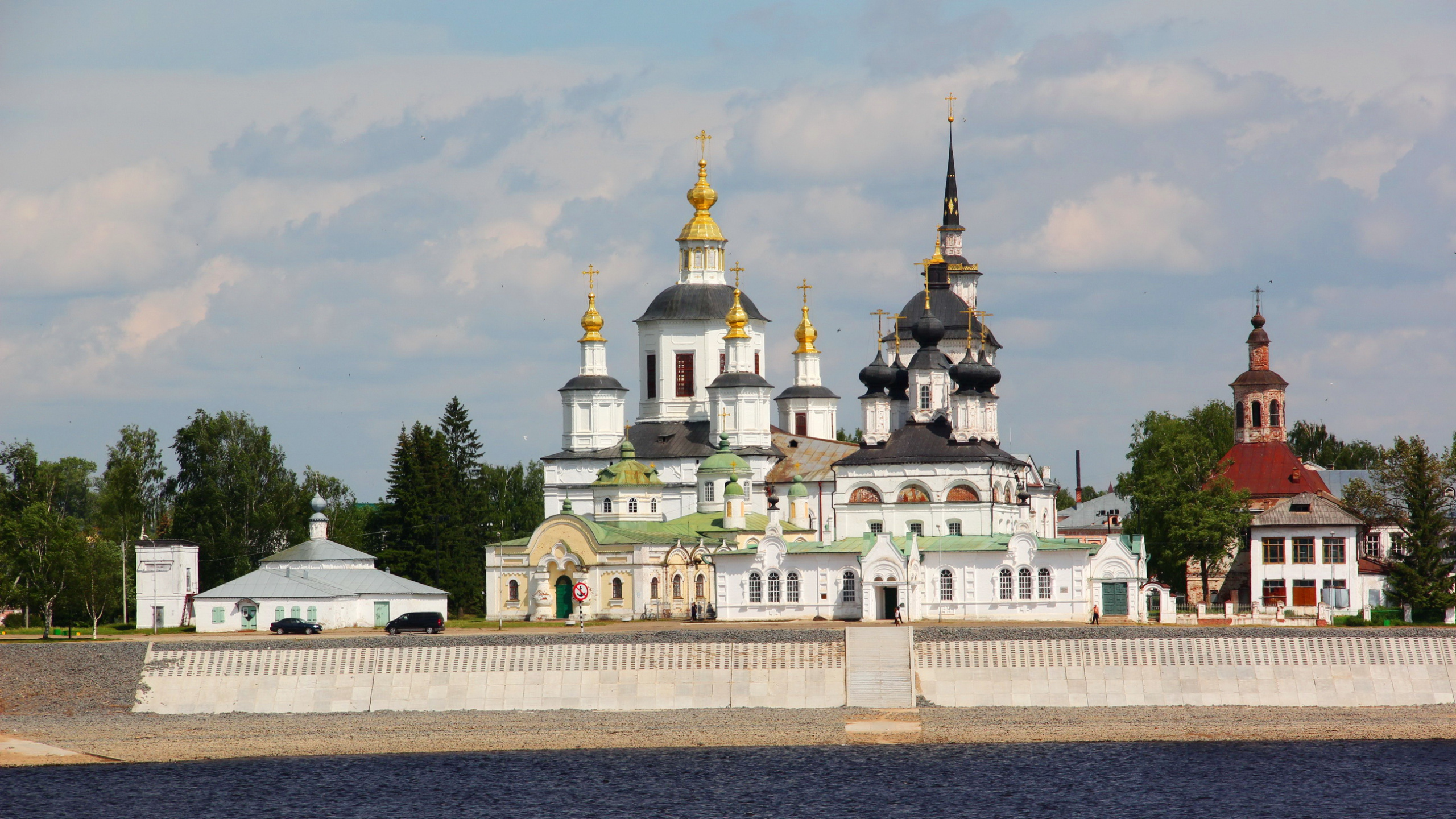 White and Gold Concrete Building Near Green Trees Under White Clouds During Daytime. Wallpaper in 2560x1440 Resolution