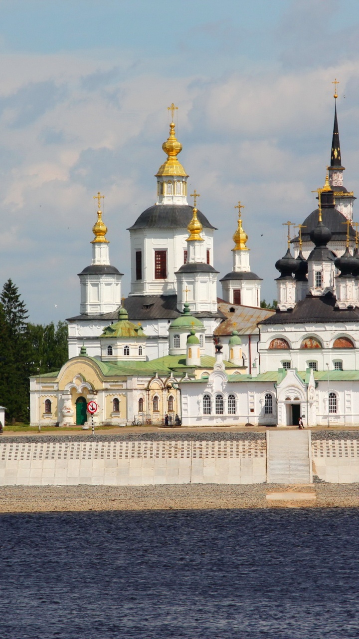 Edificio de Hormigón Blanco y Dorado Cerca de Árboles Verdes Bajo Nubes Blancas Durante el Día. Wallpaper in 720x1280 Resolution