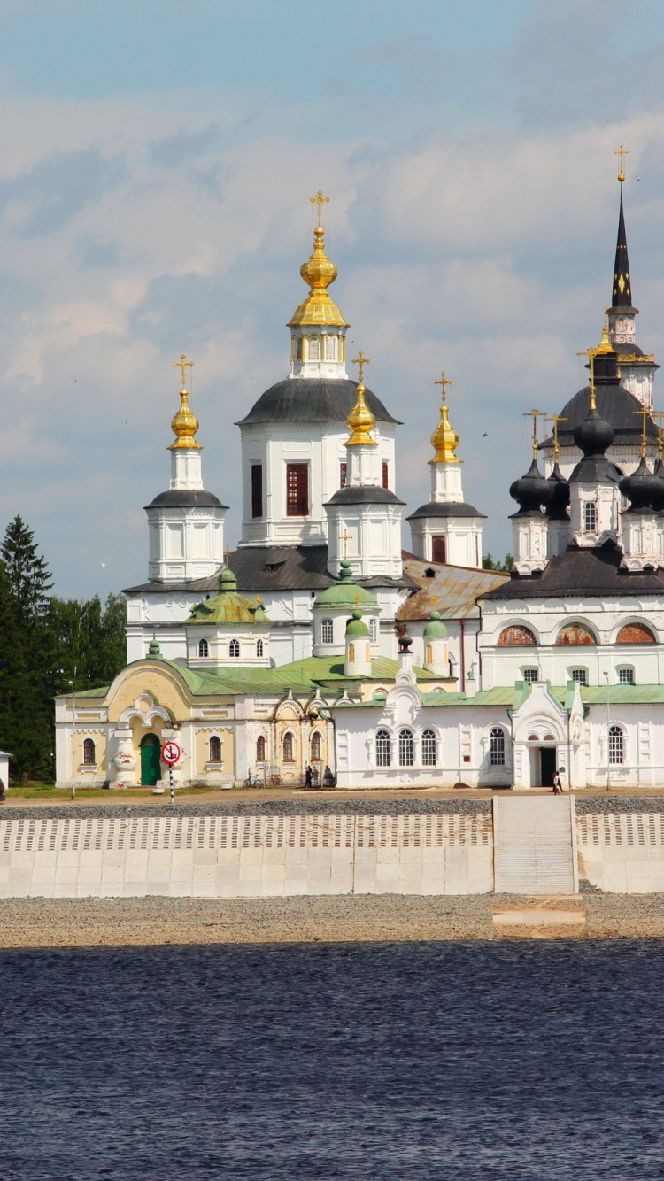 Weißes Und Goldenes Betongebäude in Der Nähe Von Grünen Bäumen Unter Weißen Wolken Tagsüber. Wallpaper in 750x1334 Resolution