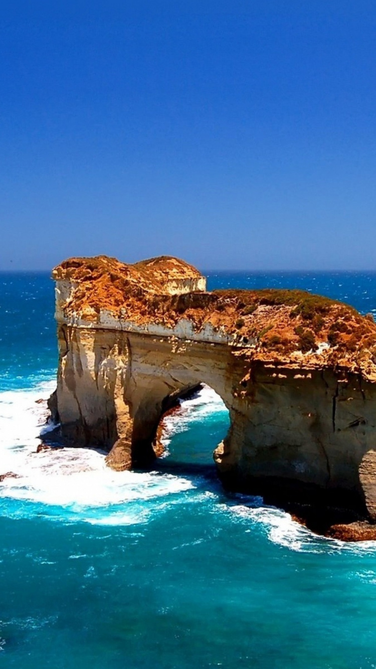Brown Rock Formation on Blue Sea Under Blue Sky During Daytime. Wallpaper in 750x1334 Resolution