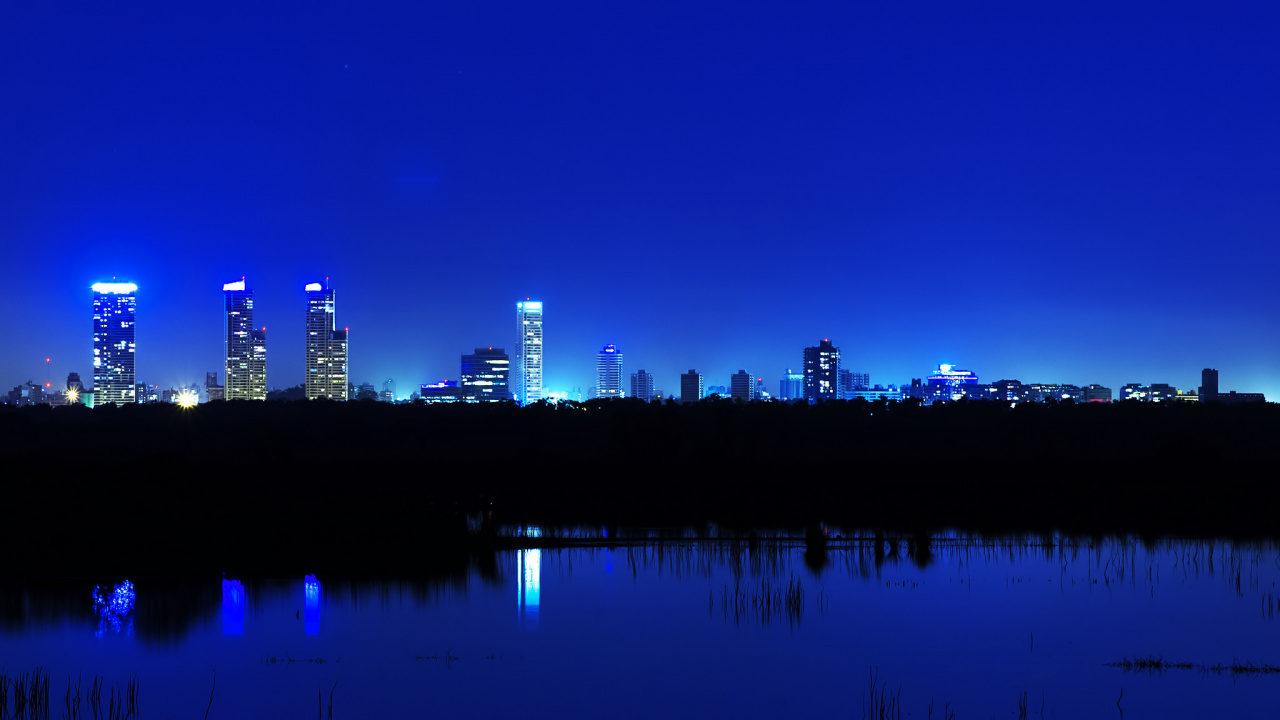 Skyline Der Stadt Über Gewässer Während Der Nacht. Wallpaper in 1280x720 Resolution