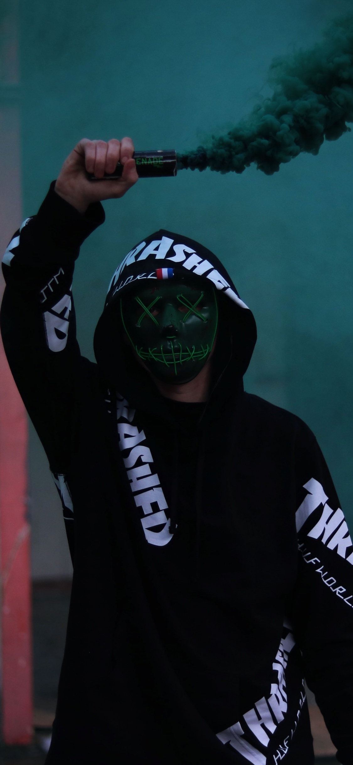 Mann in Schwarz-weißem Adidas Hoodie Mit Grünem Rauch. Wallpaper in 1125x2436 Resolution