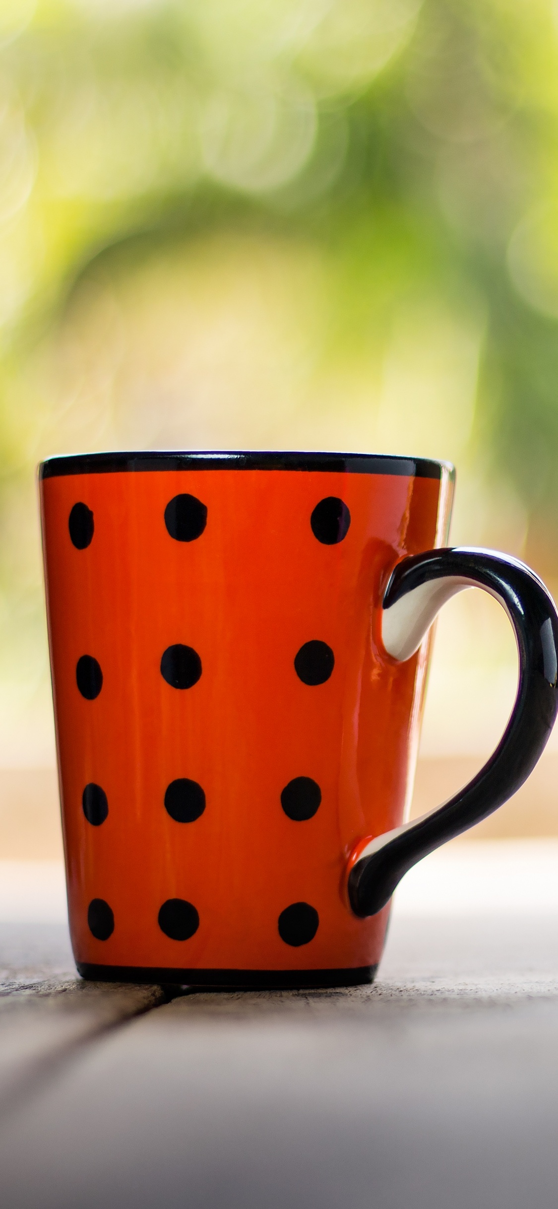 Rot-weiß Gepunktete Keramiktasse Auf Weißem Tisch. Wallpaper in 1125x2436 Resolution