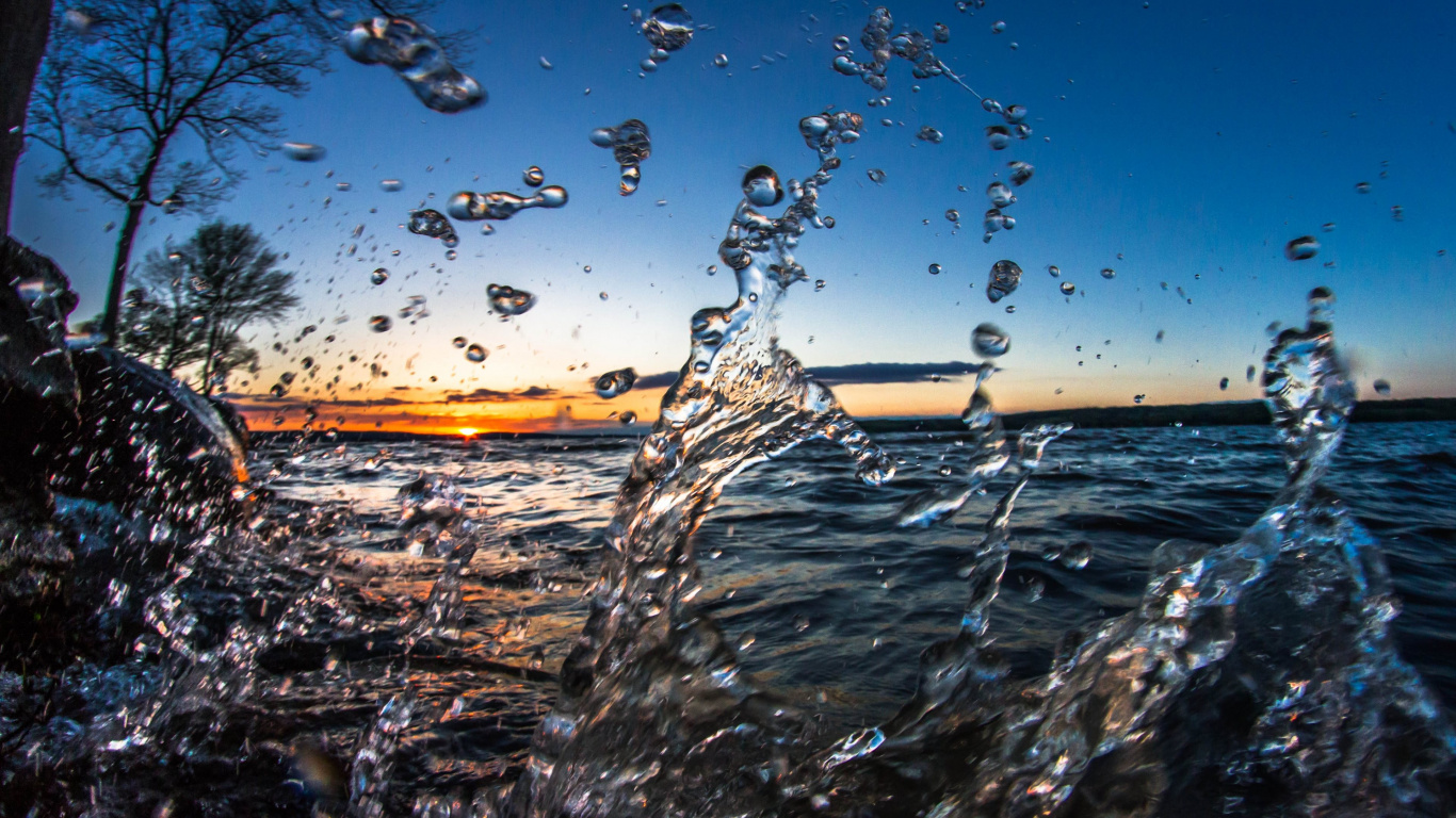 Éclaboussures D'eau Sur le Rivage Rocheux Brun Pendant le Coucher du Soleil. Wallpaper in 1366x768 Resolution