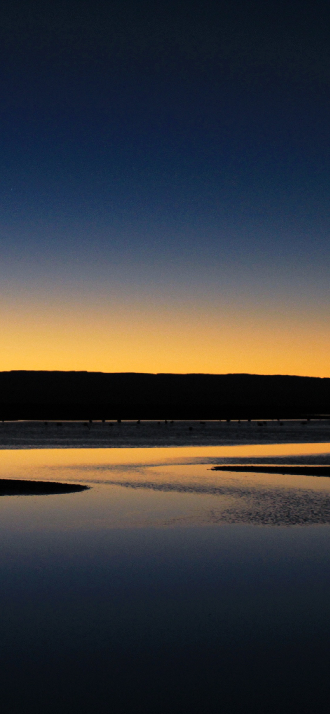 Silhouette of Mountain Near Body of Water During Daytime. Wallpaper in 1125x2436 Resolution