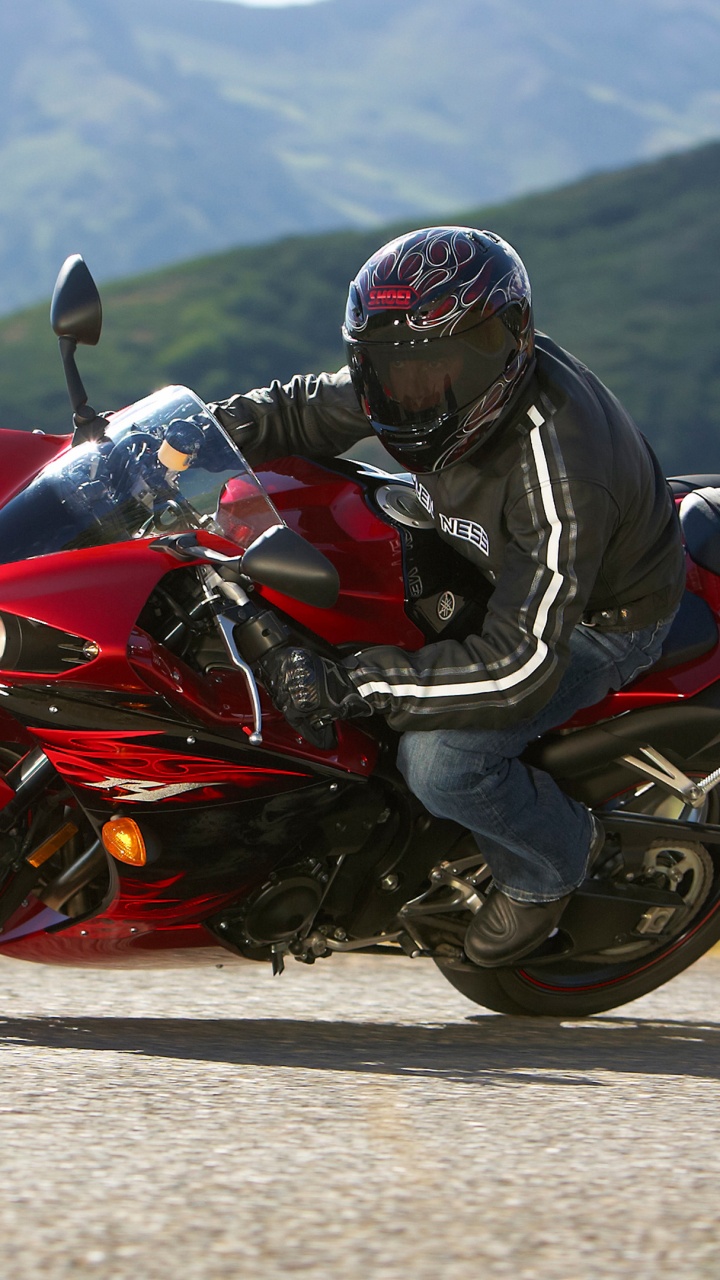 Hombre Con Chaqueta Negra Montando Bicicleta Deportiva Roja. Wallpaper in 720x1280 Resolution