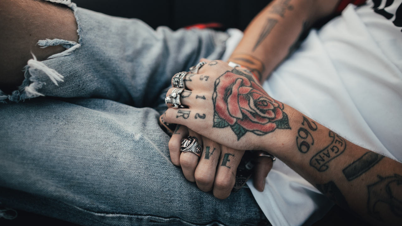 Person Mit Schwarzer Und Roter Rose Tattoo am Linken Arm. Wallpaper in 1280x720 Resolution