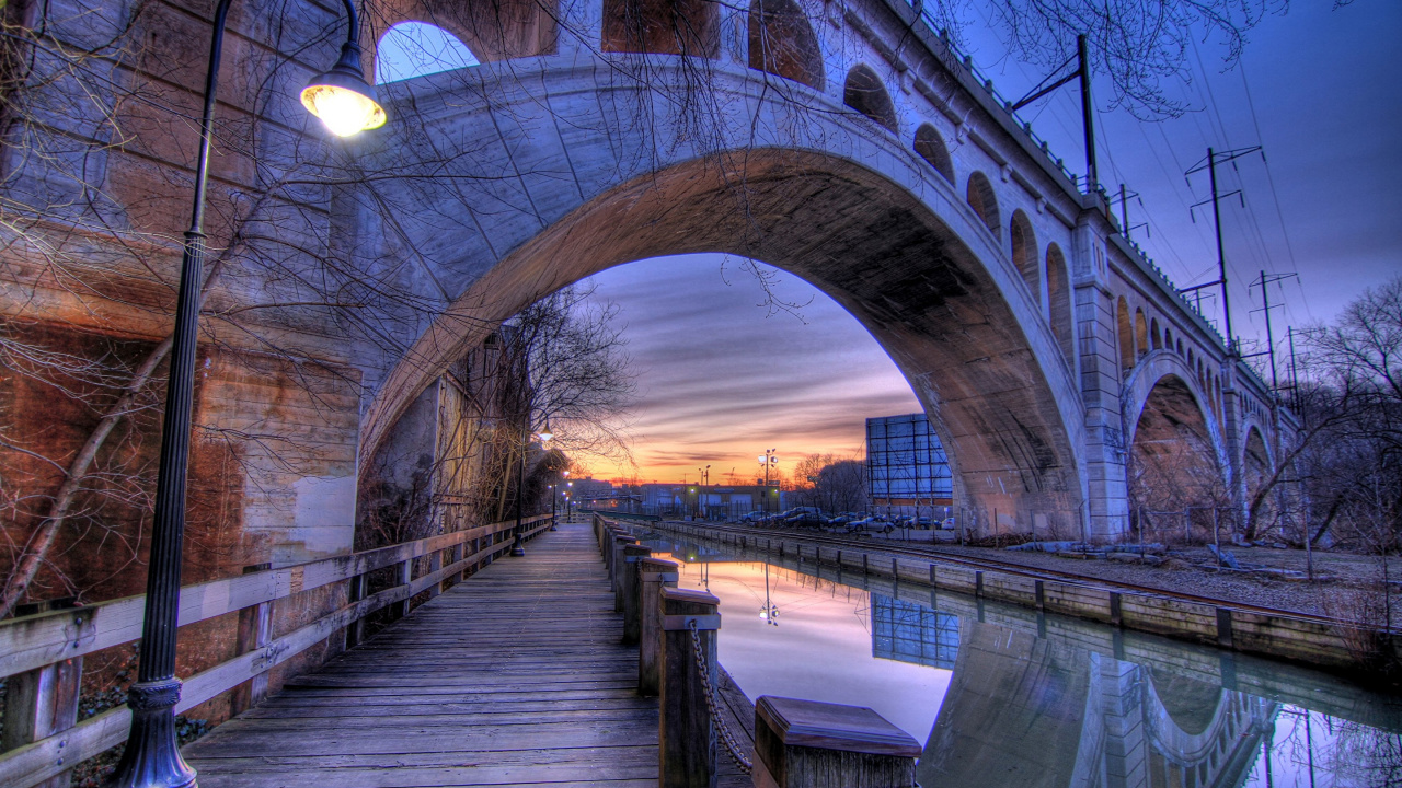 Braune Holzbrücke Über Den Fluss Bei Sonnenuntergang. Wallpaper in 1280x720 Resolution