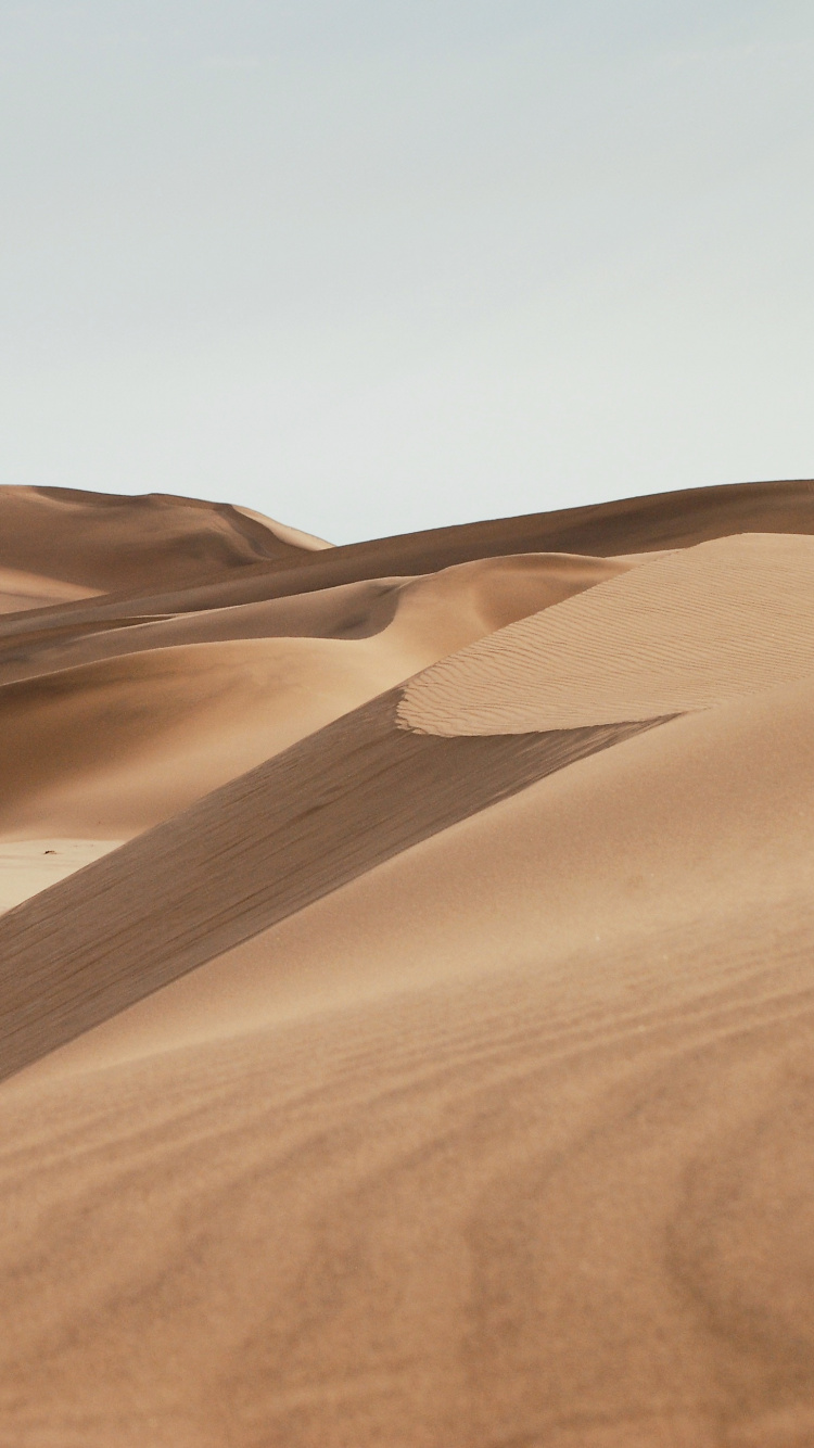 Brown Sand Under Blue Sky During Daytime. Wallpaper in 750x1334 Resolution