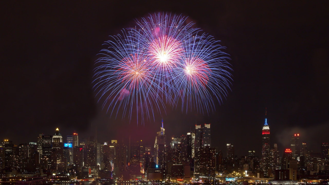 Fireworks Display Over City Buildings During Night Time. Wallpaper in 1280x720 Resolution