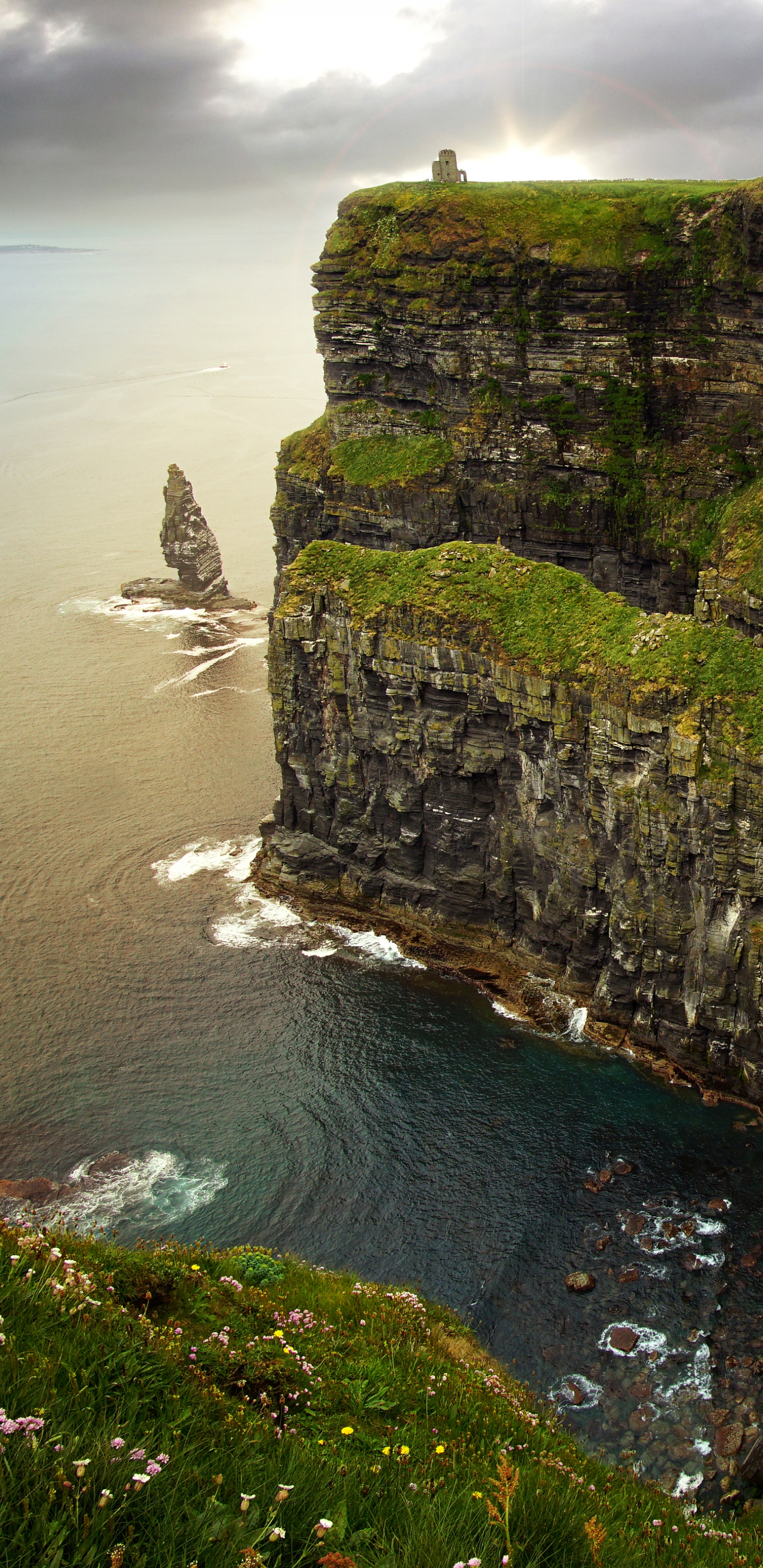 Gray and Green Rock Formation Beside Body of Water During Daytime. Wallpaper in 1440x2960 Resolution