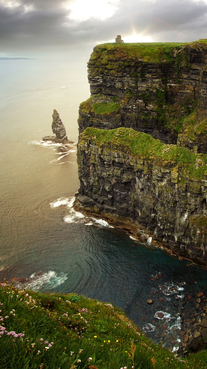 Gray and Green Rock Formation Beside Body of Water During Daytime. Wallpaper in 720x1280 Resolution