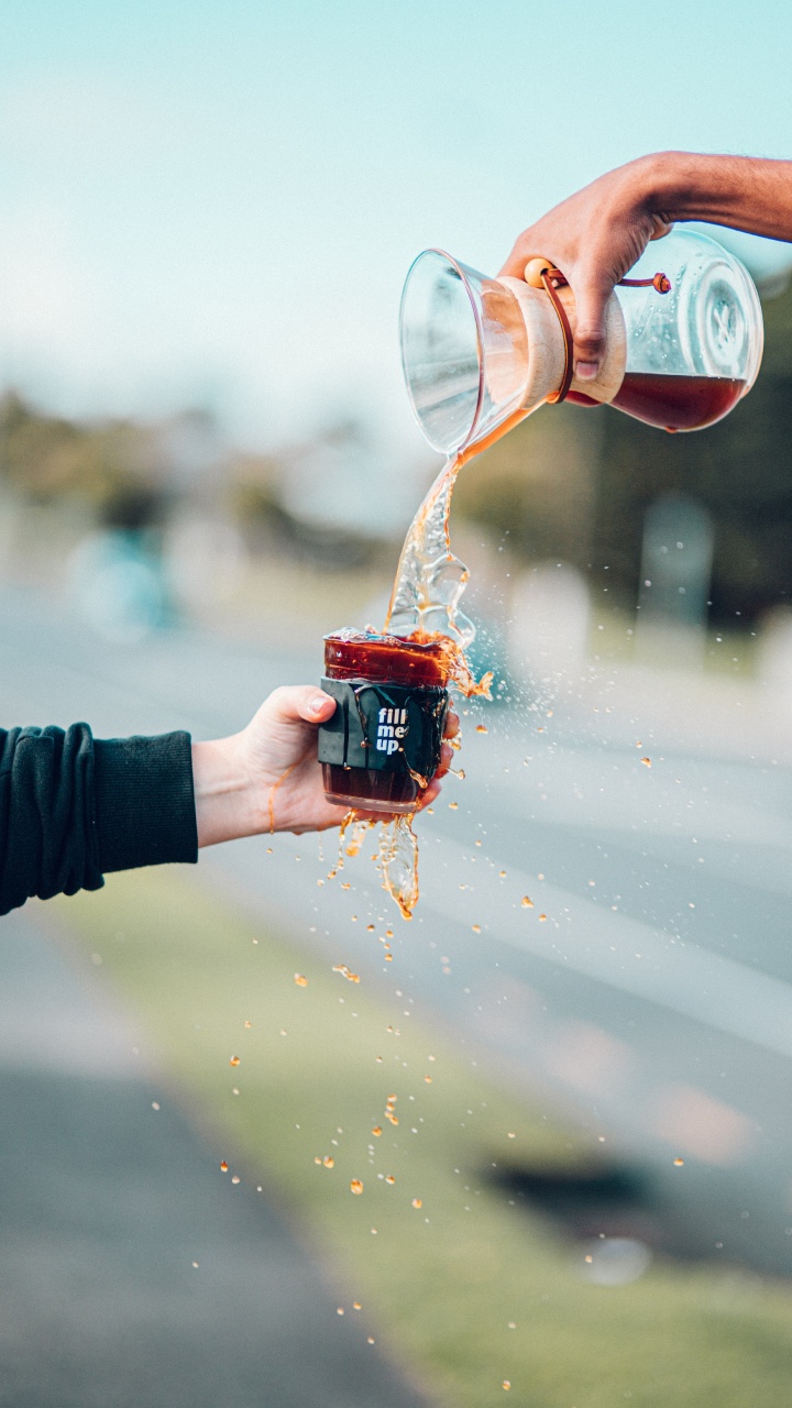 Personne Versant de L'eau Sur Une Tasse en Céramique Rouge. Wallpaper in 720x1280 Resolution