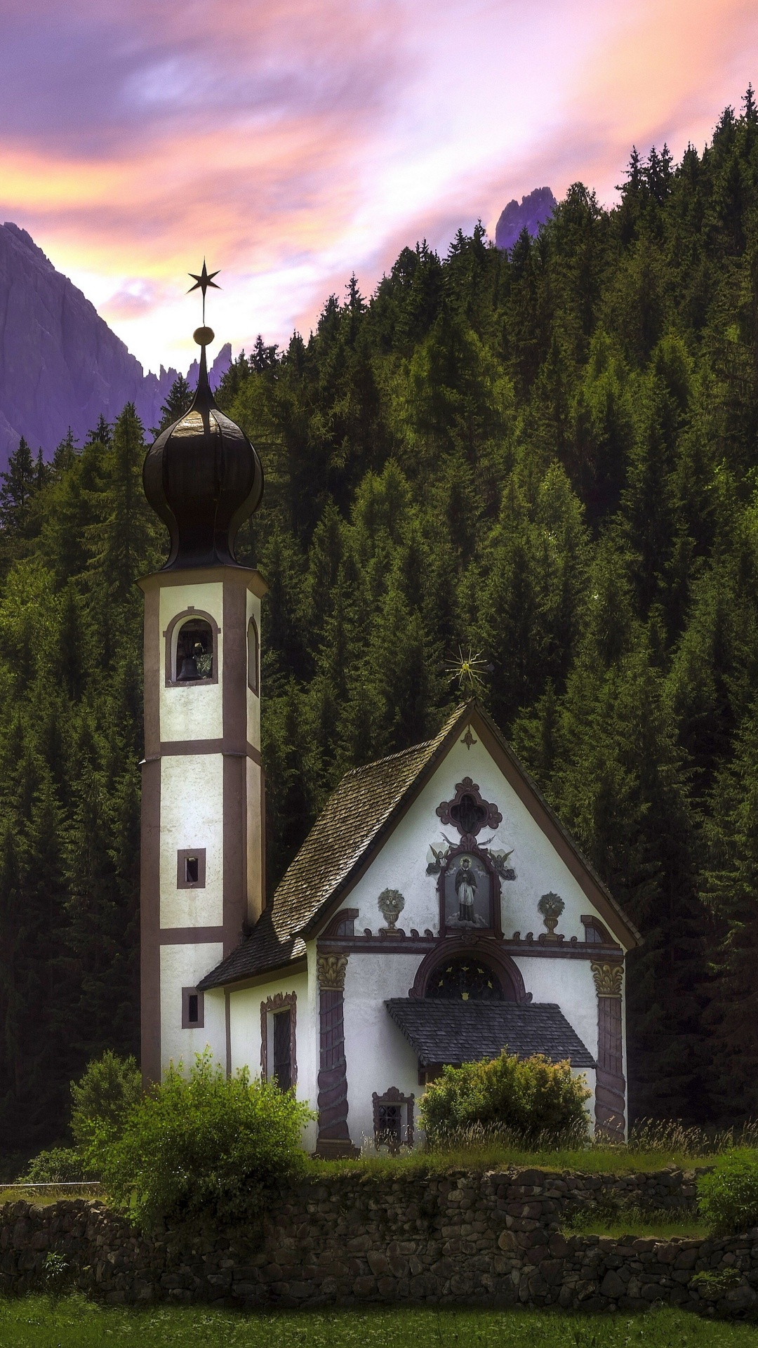 Weiße Und Schwarze Kirche Auf Grünem Grasfeld in Der Nähe Von Grünen Bäumen Und Bergen Tagsüber. Wallpaper in 1080x1920 Resolution