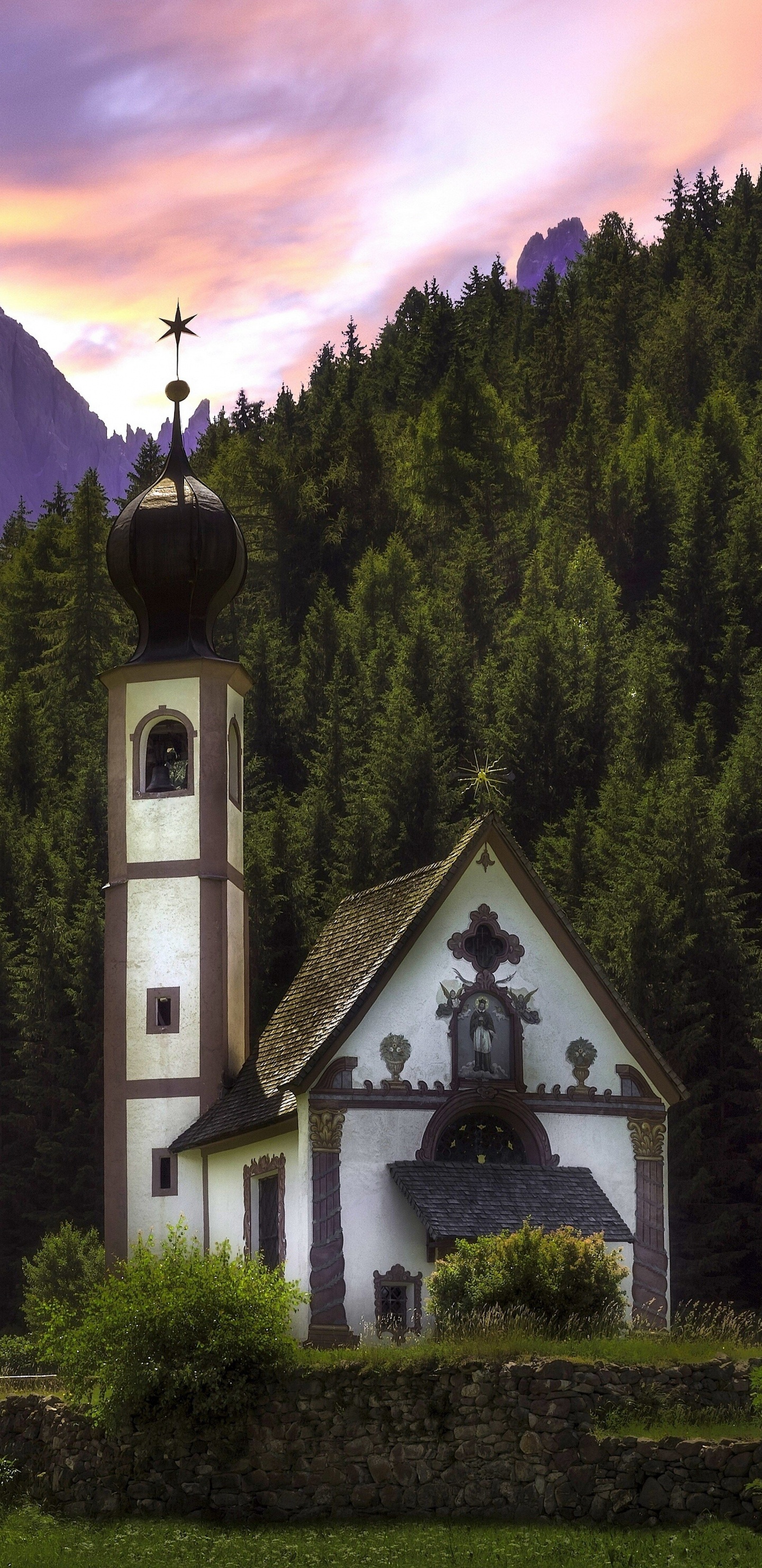 Weiße Und Schwarze Kirche Auf Grünem Grasfeld in Der Nähe Von Grünen Bäumen Und Bergen Tagsüber. Wallpaper in 1440x2960 Resolution