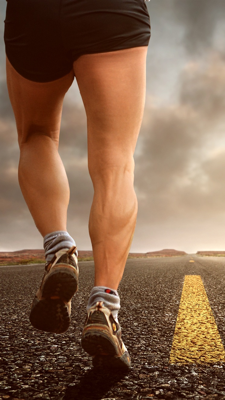 Person in Black Shorts and Black and White Sneakers Running on Black Asphalt Road During Daytime. Wallpaper in 750x1334 Resolution