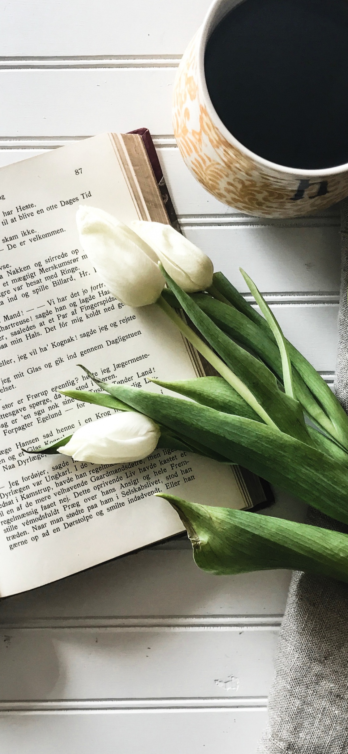 White Book Page Beside White Ceramic Mug. Wallpaper in 1125x2436 Resolution