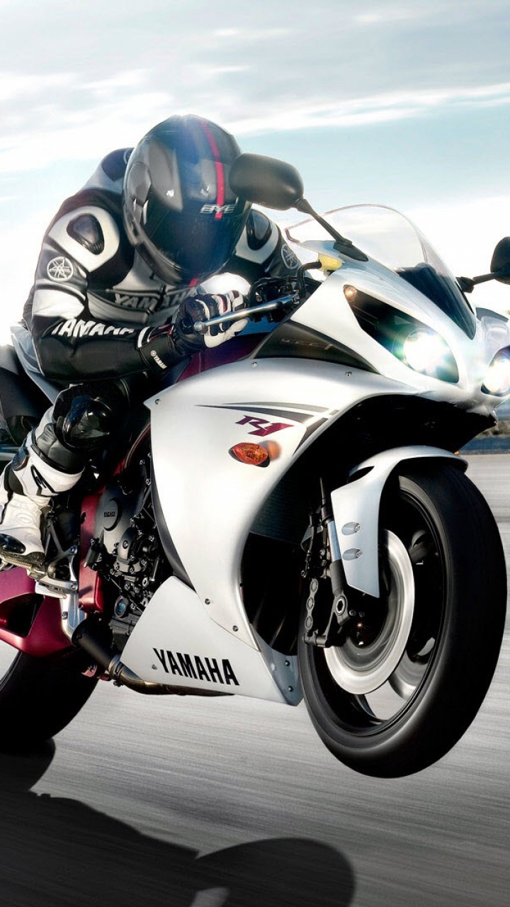 Mann in Schwarz-rotem Motorradhelm, Der Während Der Fahrt Ein Weißes Und Schwarzes Sportrad Auf Der Straße Fährt. Wallpaper in 720x1280 Resolution