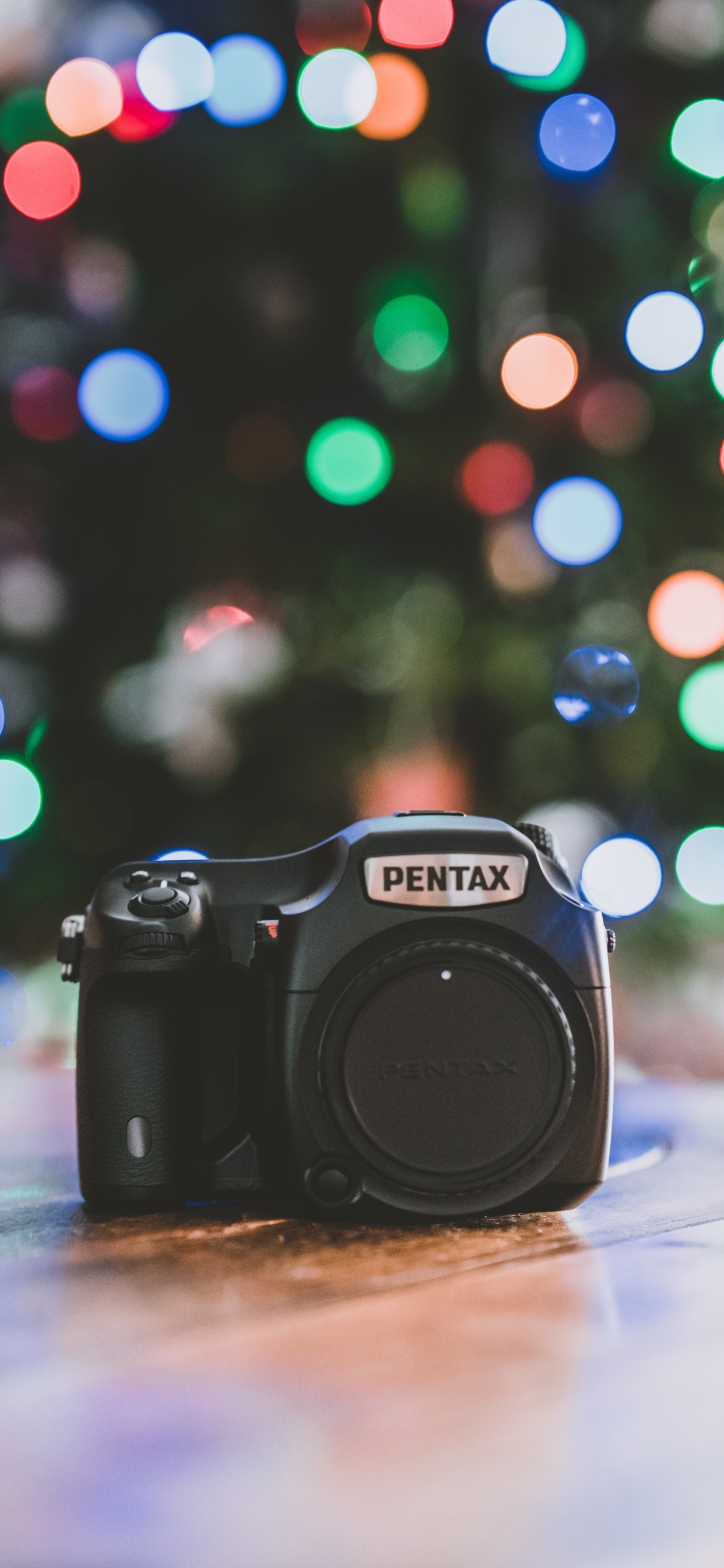 Cámara Réflex Digital Nikon Negra Sobre Mesa Blanca. Wallpaper in 1242x2688 Resolution