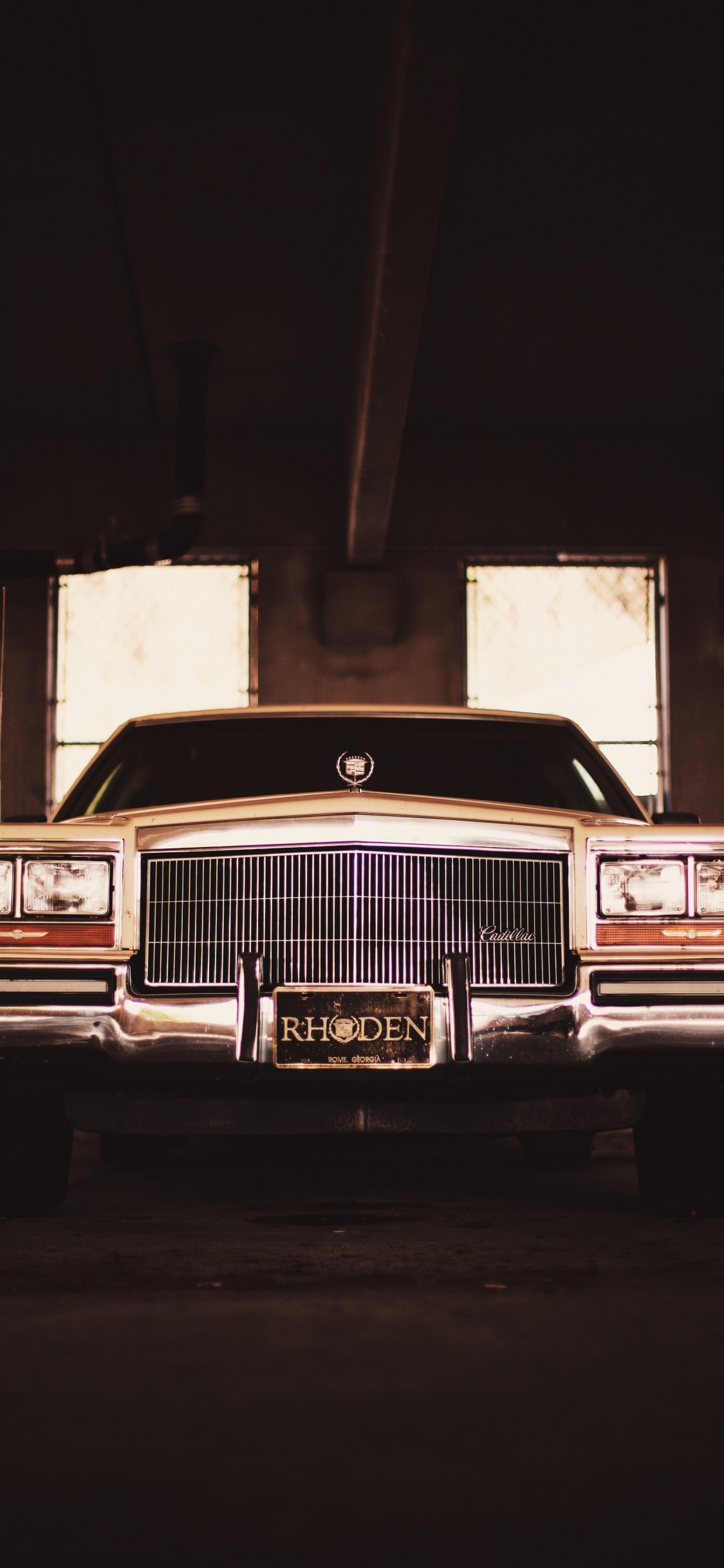 Classic Brown Car in a Garage. Wallpaper in 1125x2436 Resolution