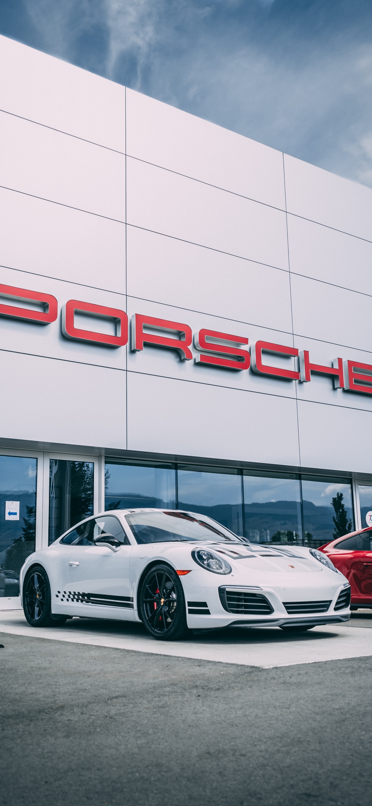 Weißer Porsche 911 Vor Weißem Gebäude Geparkt. Wallpaper in 1242x2688 Resolution