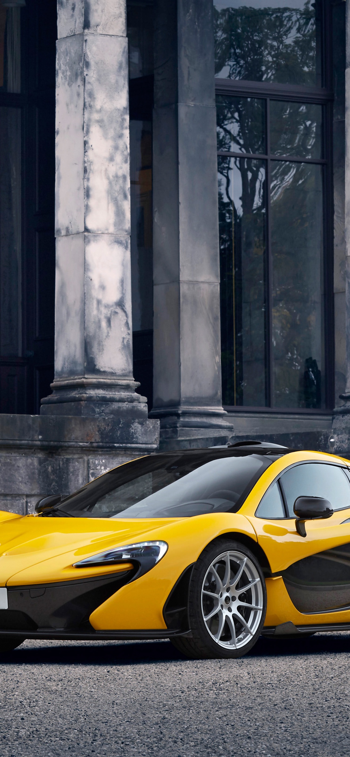 Ferrari 458 Italia Jaune Garée à Côté D'un Bâtiment en Béton Gris. Wallpaper in 1125x2436 Resolution
