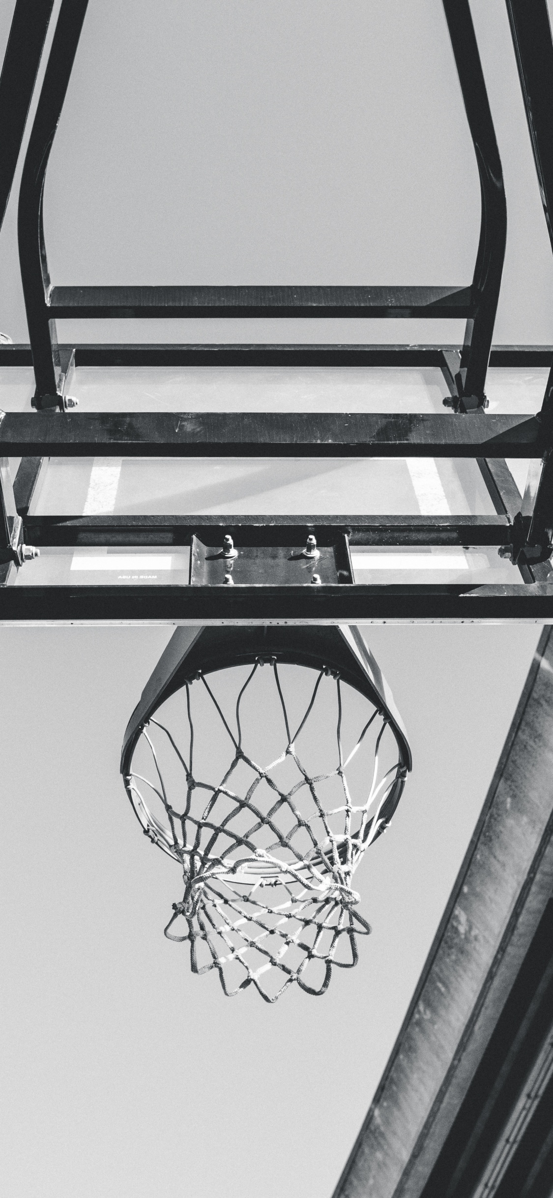 Black Basketball Hoop on White Wall. Wallpaper in 1125x2436 Resolution