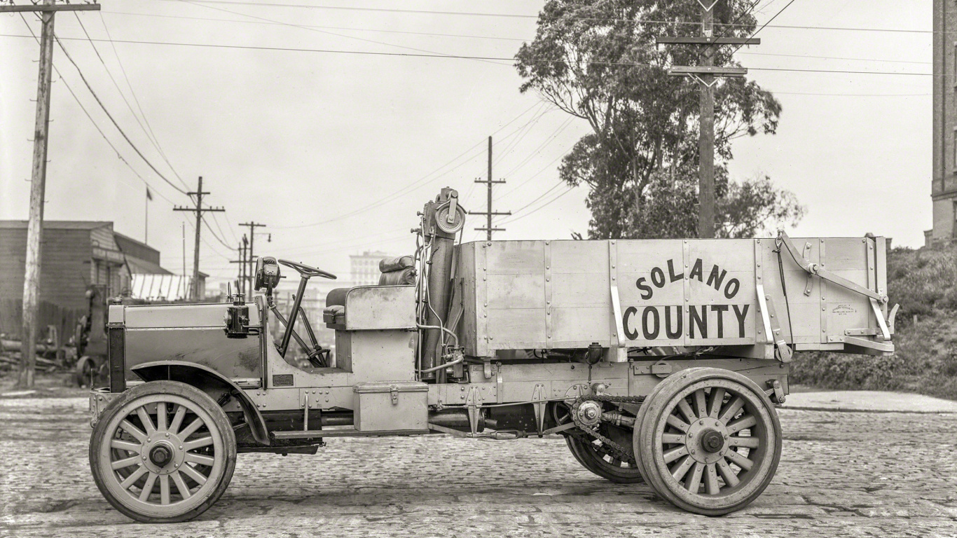 Grayscale Photo of a Trailer Truck Parked Near Trees. Wallpaper in 1366x768 Resolution