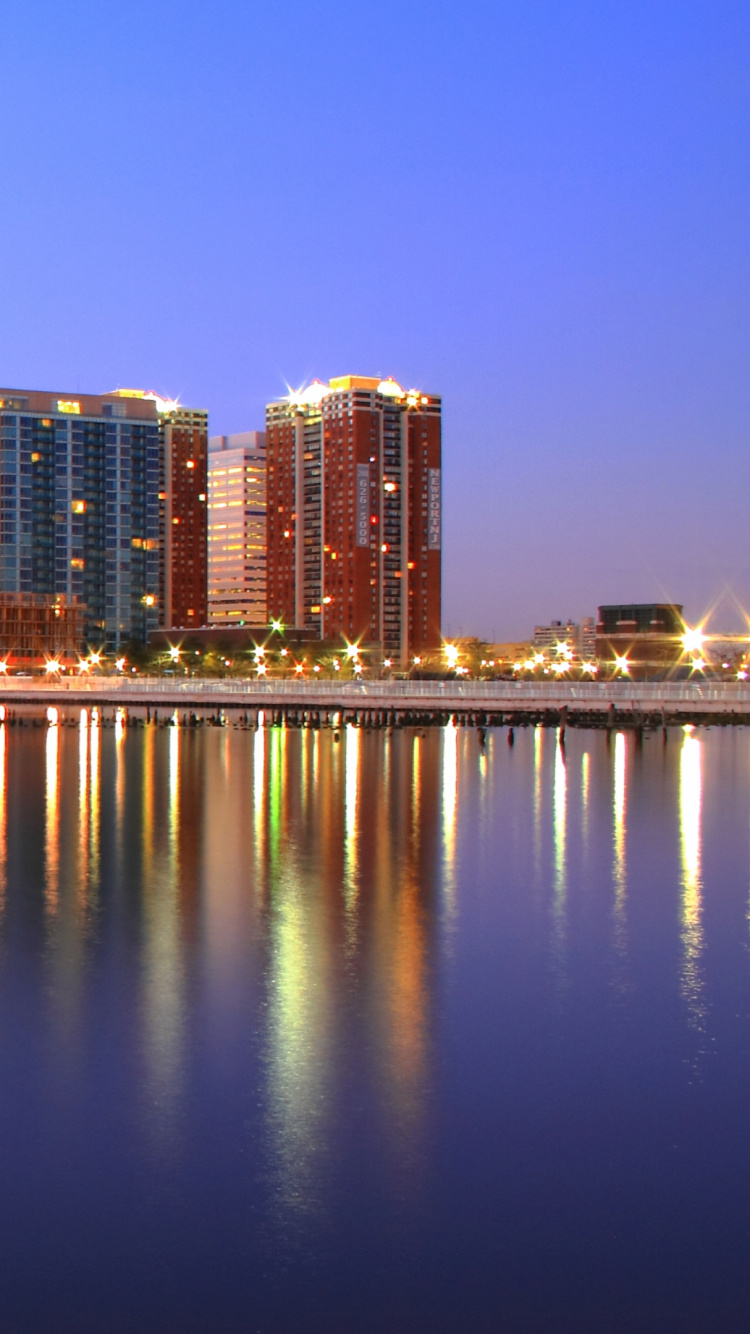 City Skyline Across Body of Water During Night Time. Wallpaper in 750x1334 Resolution