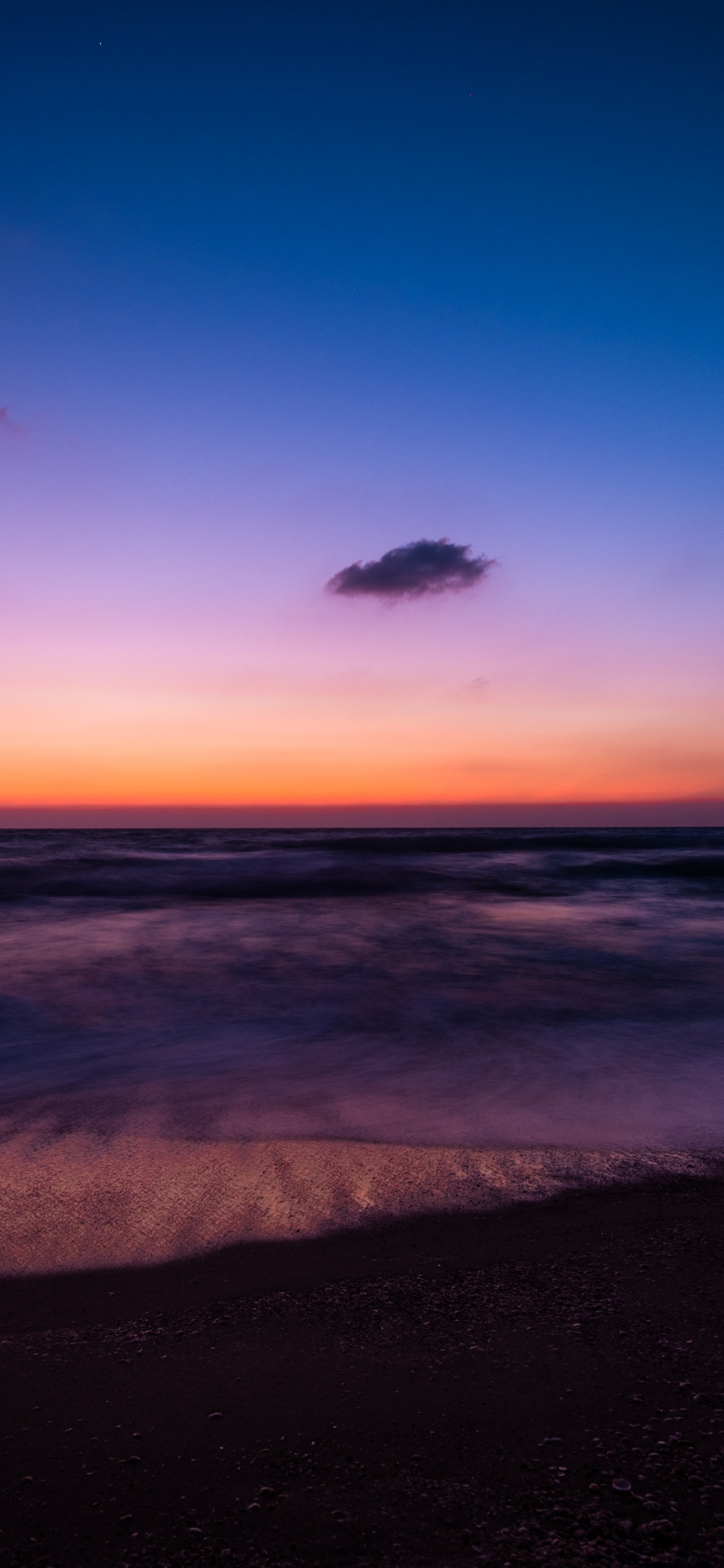 Les Vagues de L'océan S'écrasent Sur le Rivage au Coucher du Soleil. Wallpaper in 1125x2436 Resolution