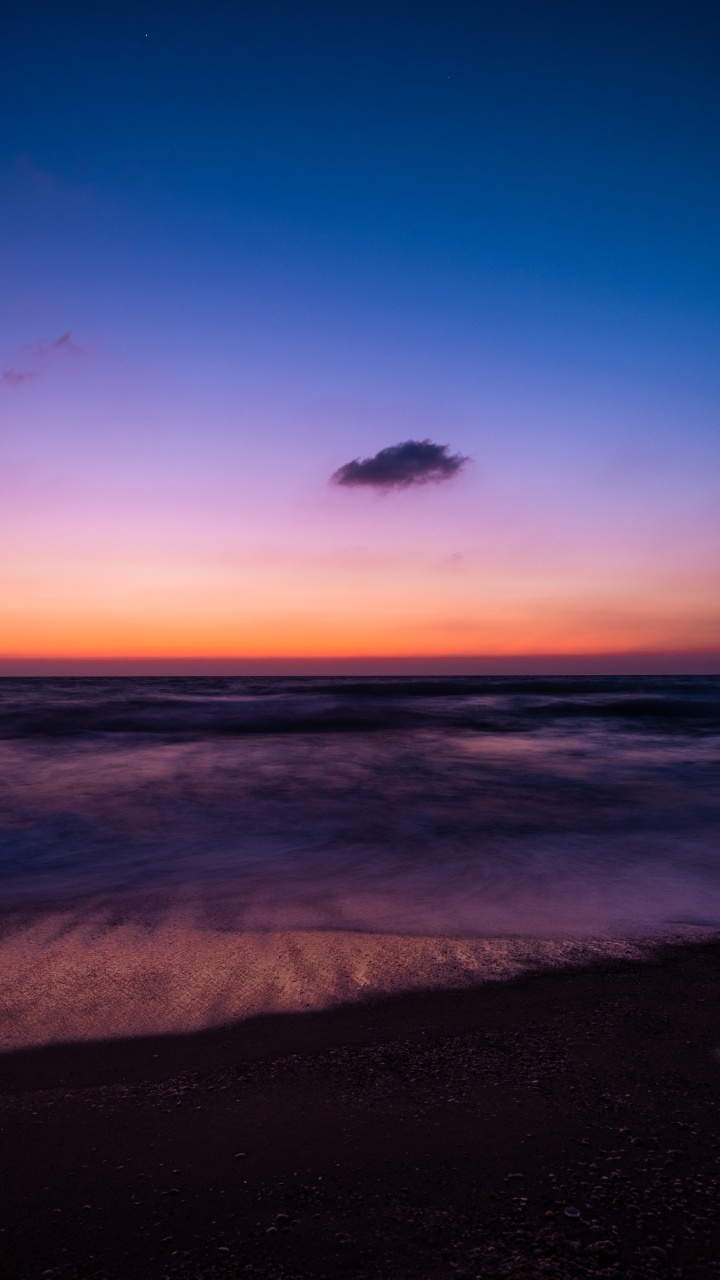 Les Vagues de L'océan S'écrasent Sur le Rivage au Coucher du Soleil. Wallpaper in 720x1280 Resolution