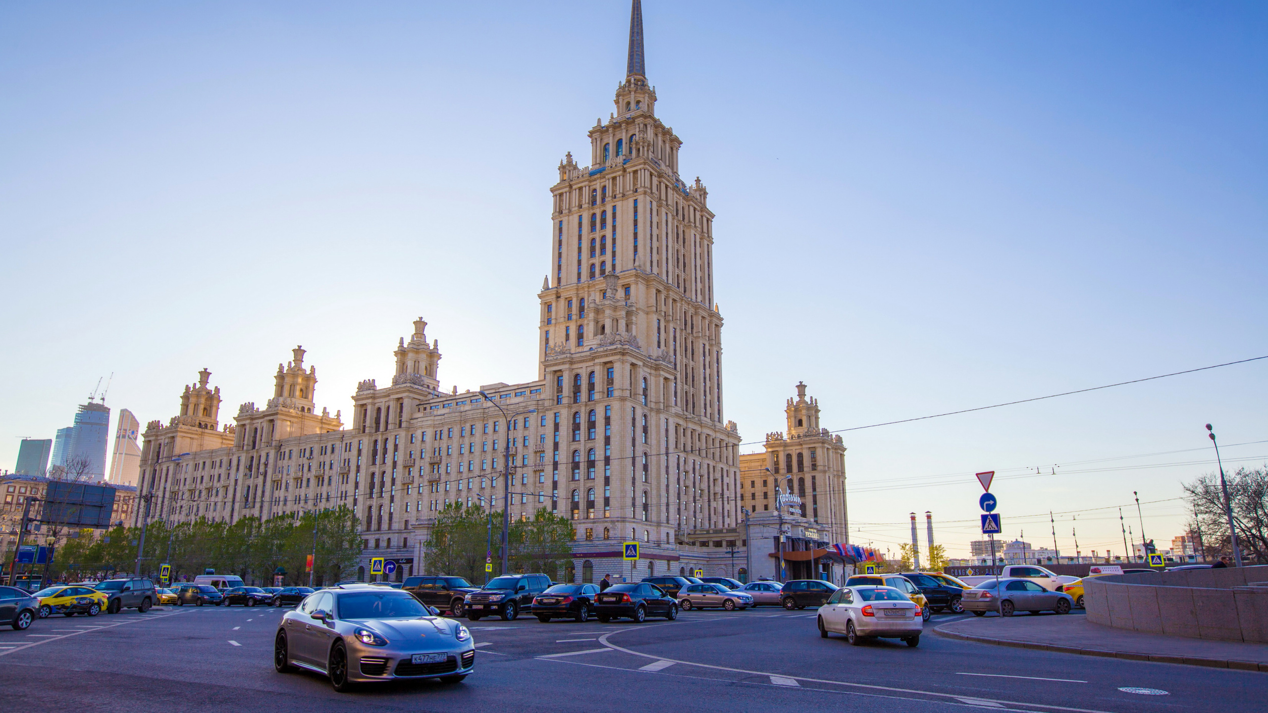 Automóviles Estacionados al Costado de la Carretera Cerca Del Edificio de Hormigón Marrón Durante el Día. Wallpaper in 2560x1440 Resolution