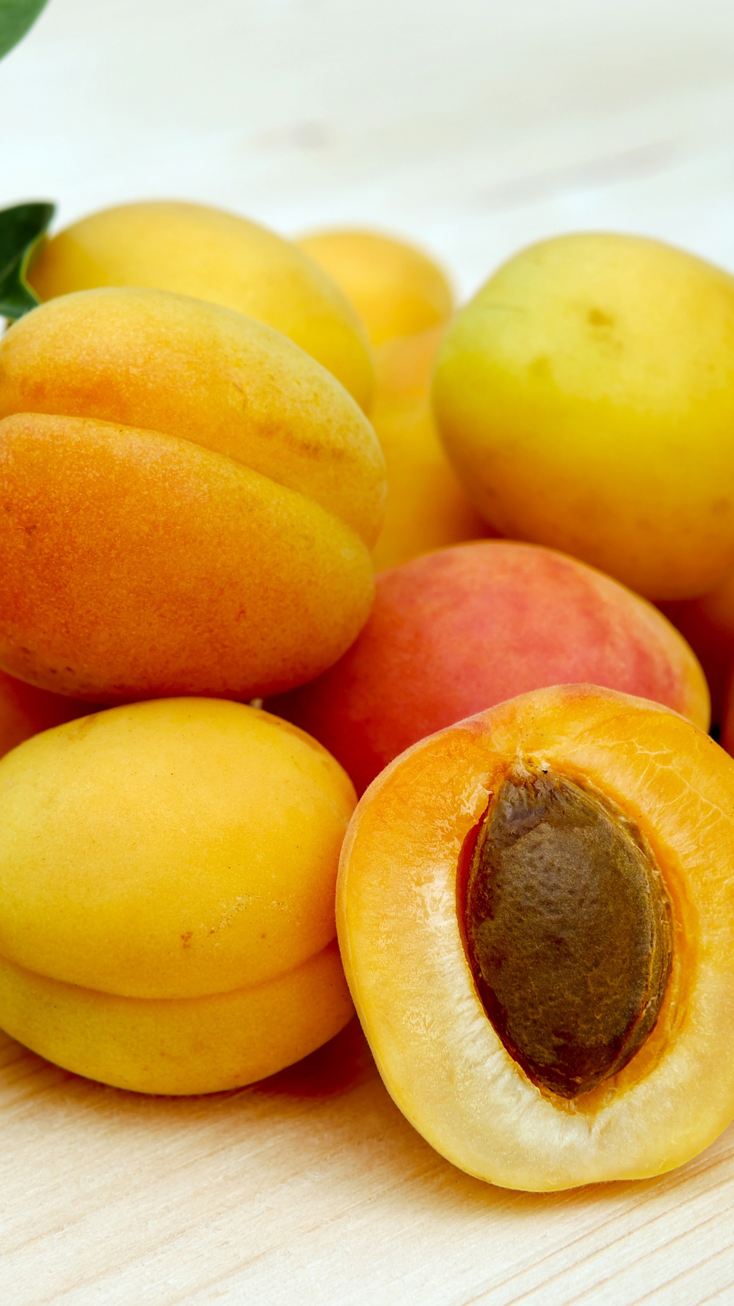 Gelbe Runde Früchte Auf Weißem Tisch. Wallpaper in 1440x2560 Resolution