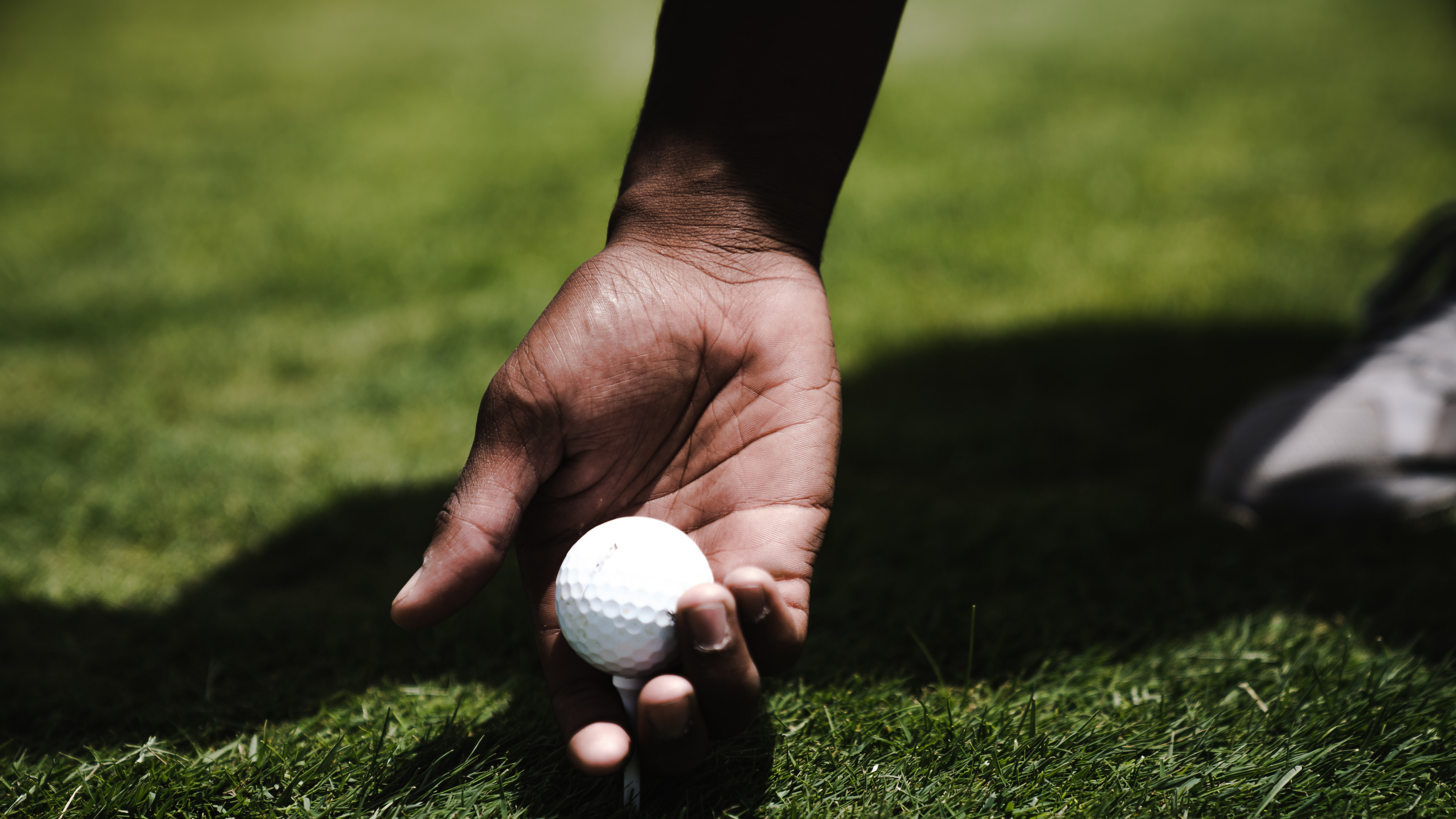 Person Holding Golf Ball on Green Grass Field During Daytime. Wallpaper in 3840x2160 Resolution