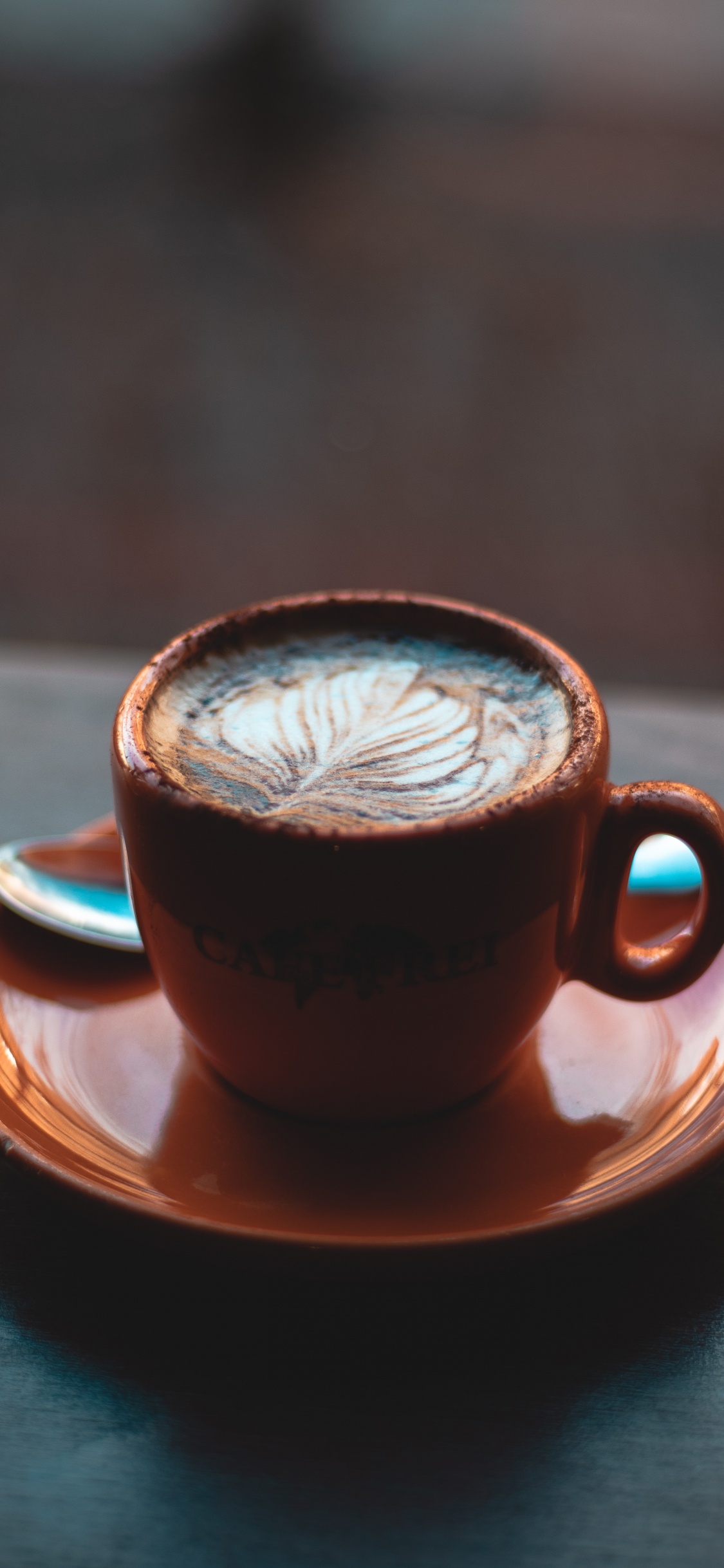 Braune Keramiktasse Mit Untertasse Auf Braunem Holztisch. Wallpaper in 1125x2436 Resolution