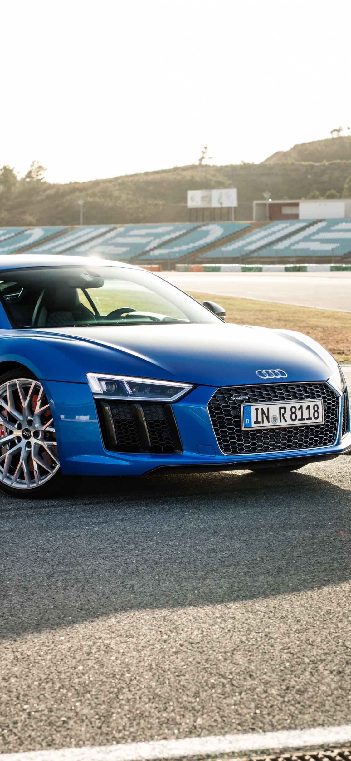 Coupé Audi Bleu Sur Route Asphaltée Grise Pendant la Journée. Wallpaper in 1125x2436 Resolution