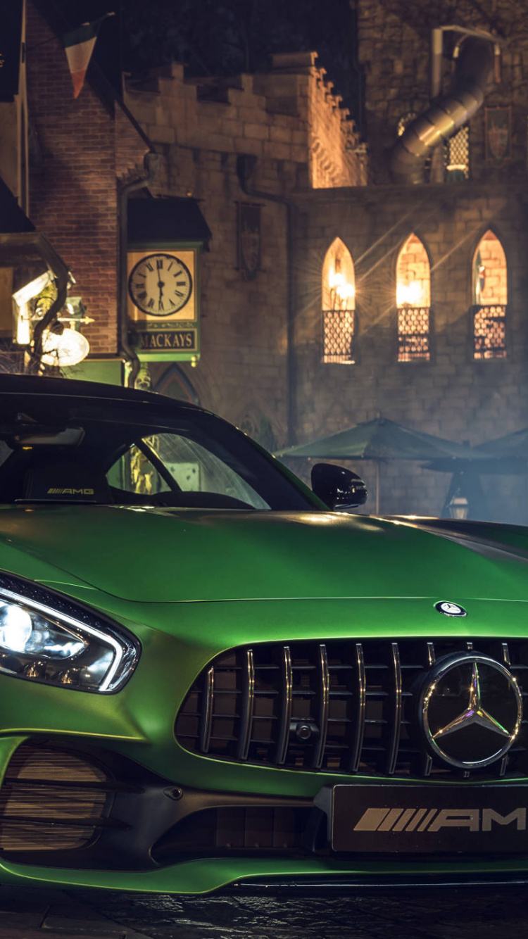 Green Car Parked Beside Brown Brick Building. Wallpaper in 750x1334 Resolution