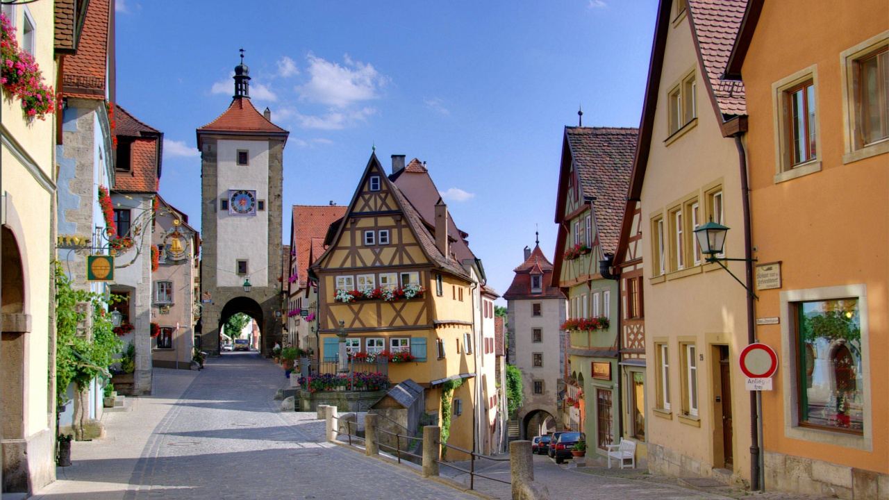 Leute, Die Tagsüber Auf Dem Bürgersteig in Der Nähe Eines Braunen Betongebäudes Gehen. Wallpaper in 1280x720 Resolution