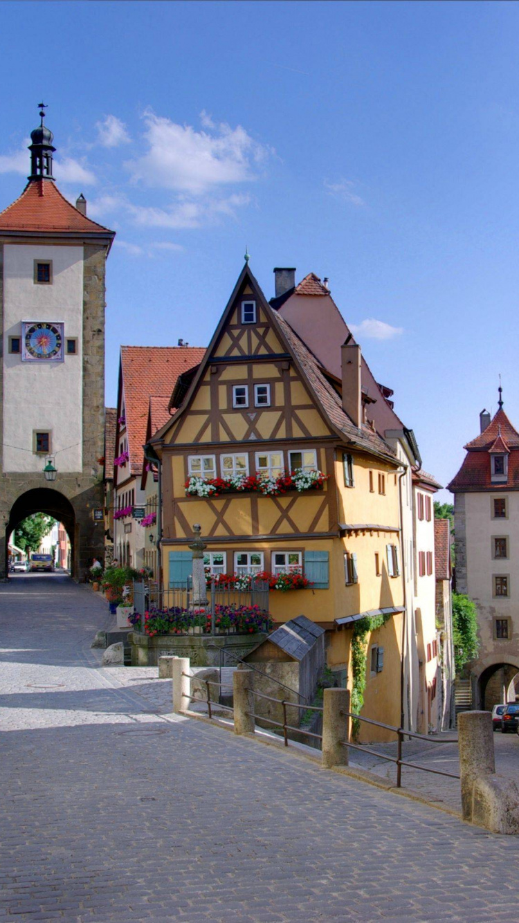 Leute, Die Tagsüber Auf Dem Bürgersteig in Der Nähe Eines Braunen Betongebäudes Gehen. Wallpaper in 750x1334 Resolution