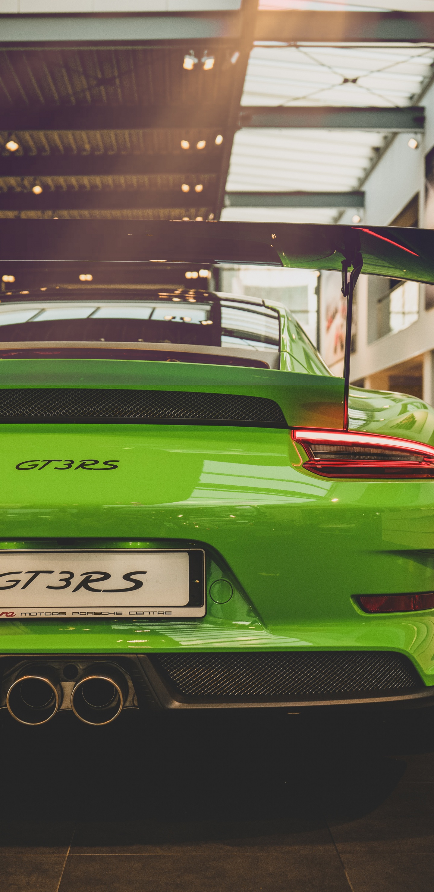 Porsche 911 Verde Estacionado Frente al Edificio. Wallpaper in 1440x2960 Resolution