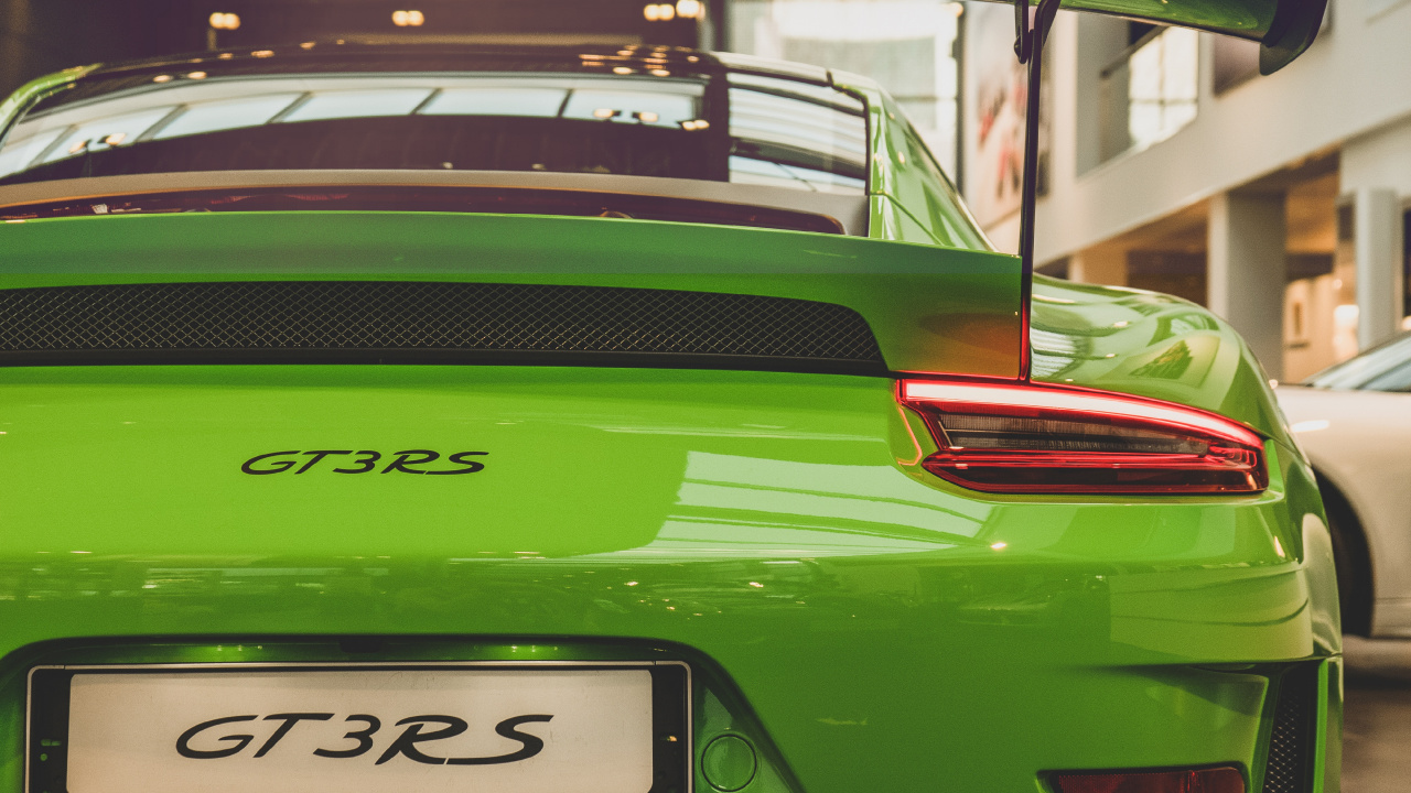 Green Porsche 911 Parked in Front of Building. Wallpaper in 1280x720 Resolution