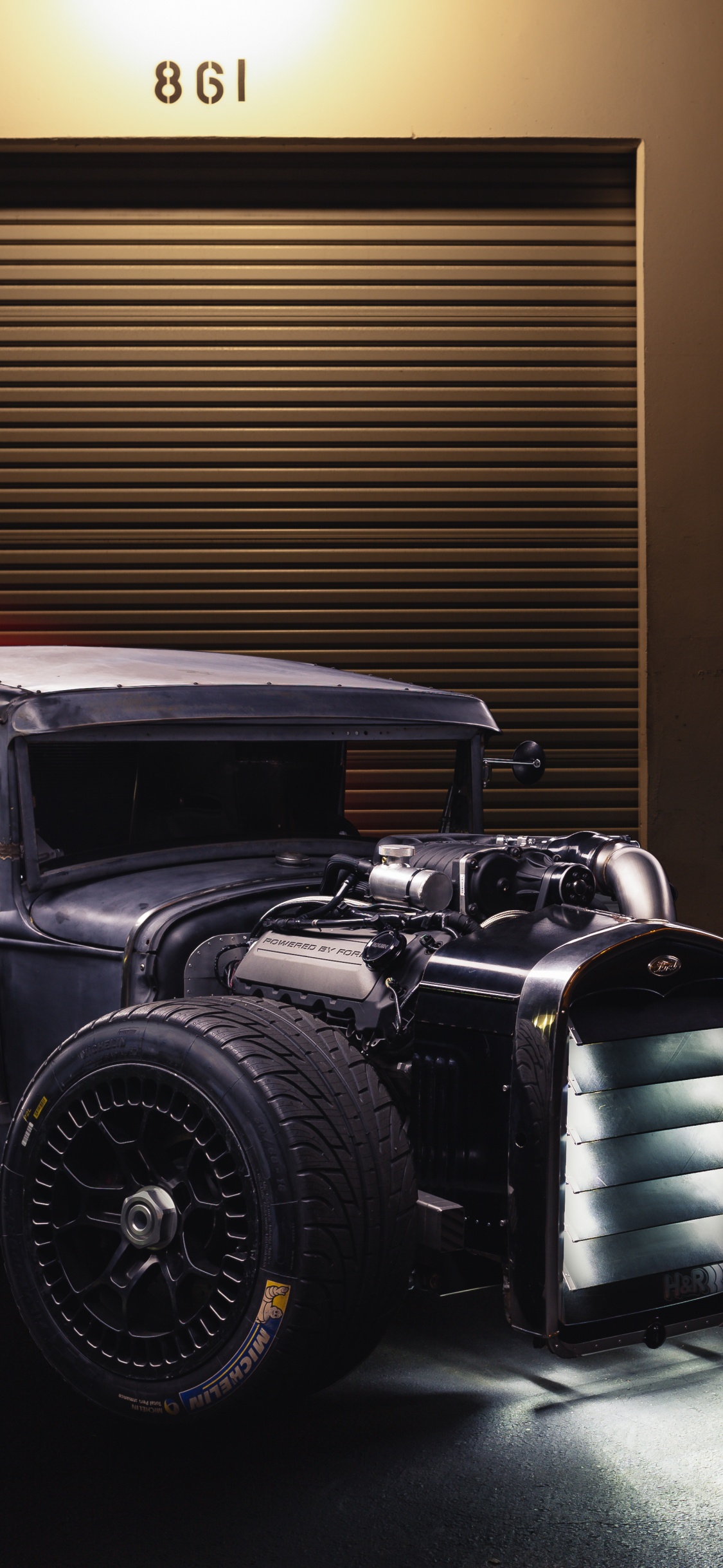 Coche de Época Negra Delante de la Pared de Madera Marrón. Wallpaper in 1125x2436 Resolution