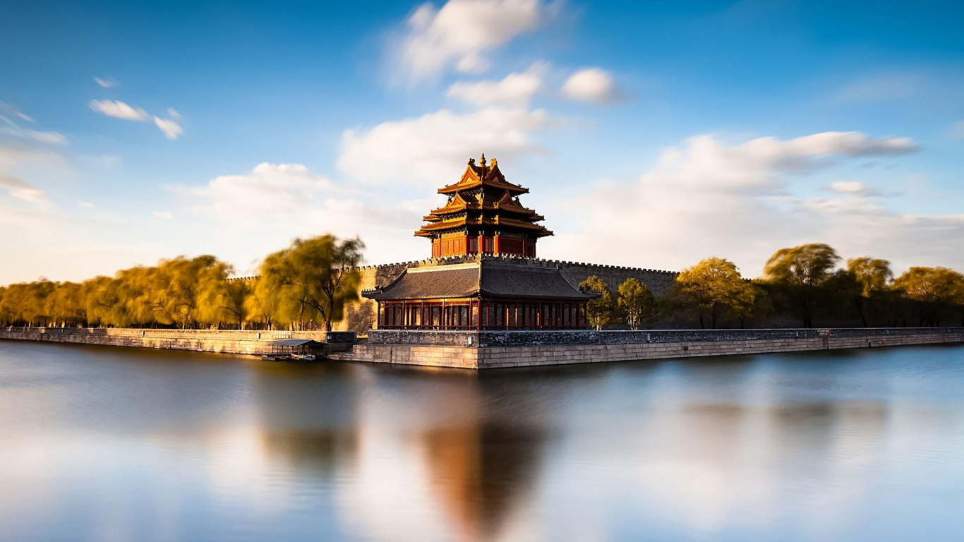 Brown and Black Concrete Building Near Body of Water Under Blue Sky During Daytime. Wallpaper in 1366x768 Resolution