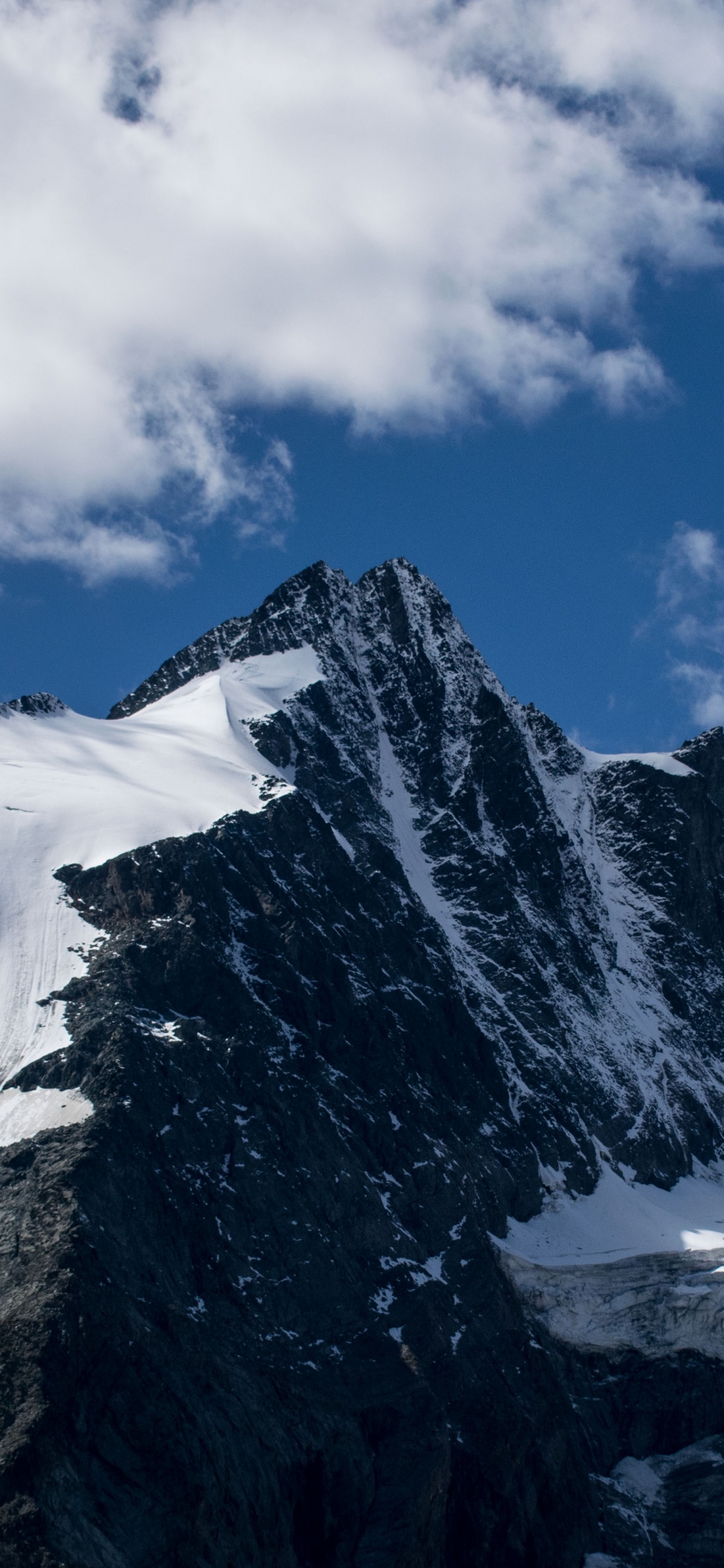 Montagne Couverte de Neige Sous un Ciel Nuageux Pendant la Journée. Wallpaper in 1125x2436 Resolution