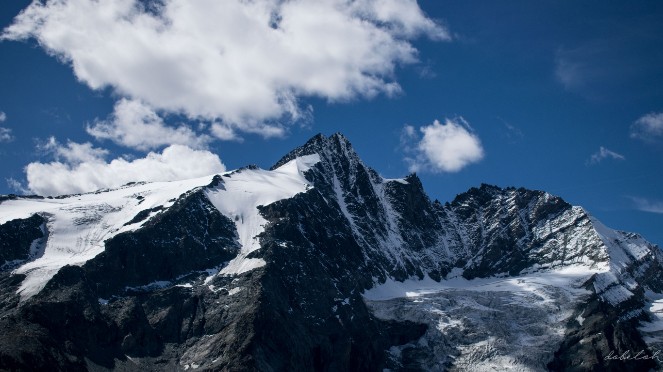 Montagne Couverte de Neige Sous un Ciel Nuageux Pendant la Journée. Wallpaper in 1366x768 Resolution