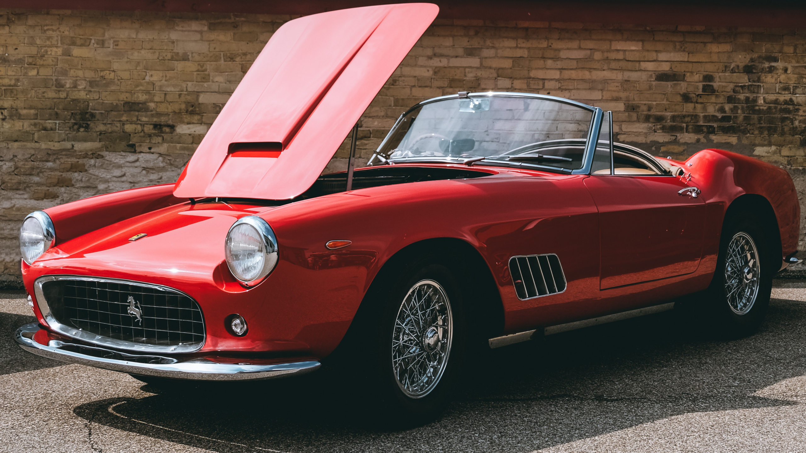 Red Ferrari 458 Italia Parked Near Brown Building. Wallpaper in 2560x1440 Resolution