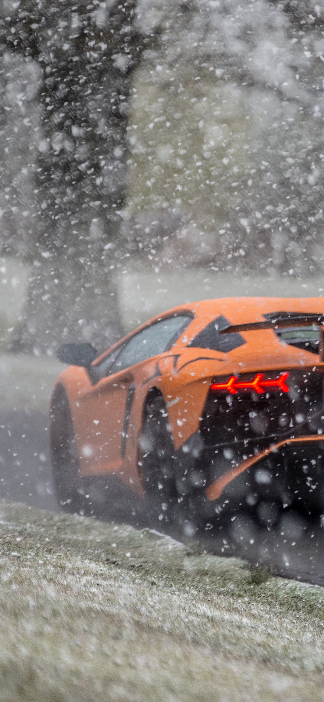 Voiture de Sport Jaune et Noir Sur Sol Couvert de Neige. Wallpaper in 1125x2436 Resolution