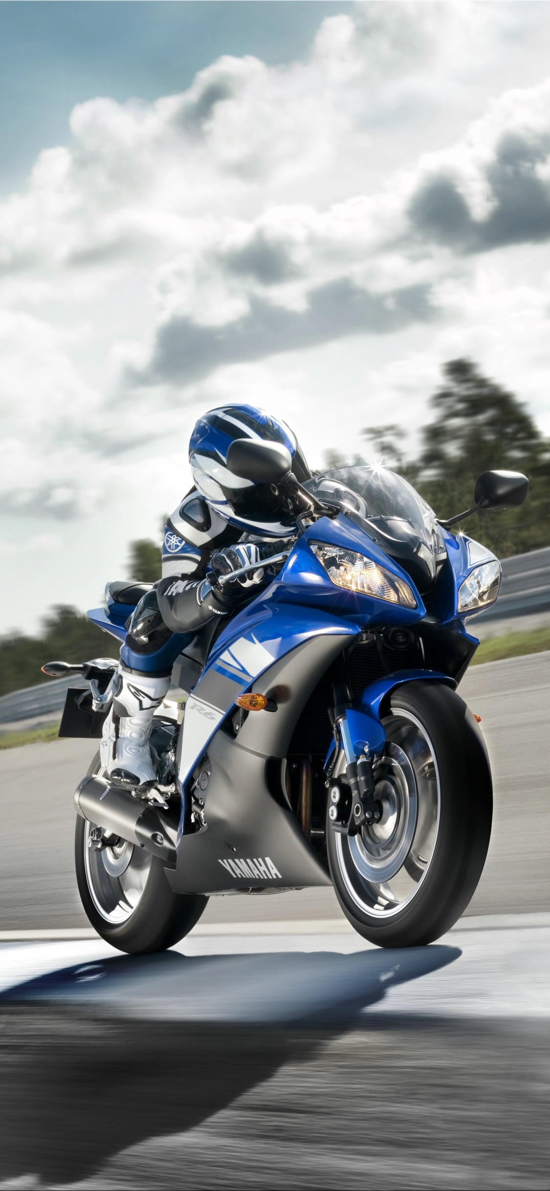 Man in Blue and White Jacket Riding Blue and White Sports Bike. Wallpaper in 1125x2436 Resolution