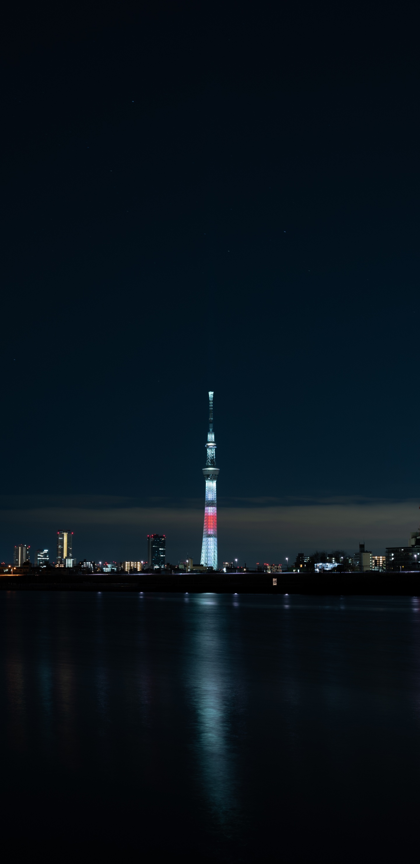 White and Red Tower Near Body of Water During Night Time. Wallpaper in 1440x2960 Resolution